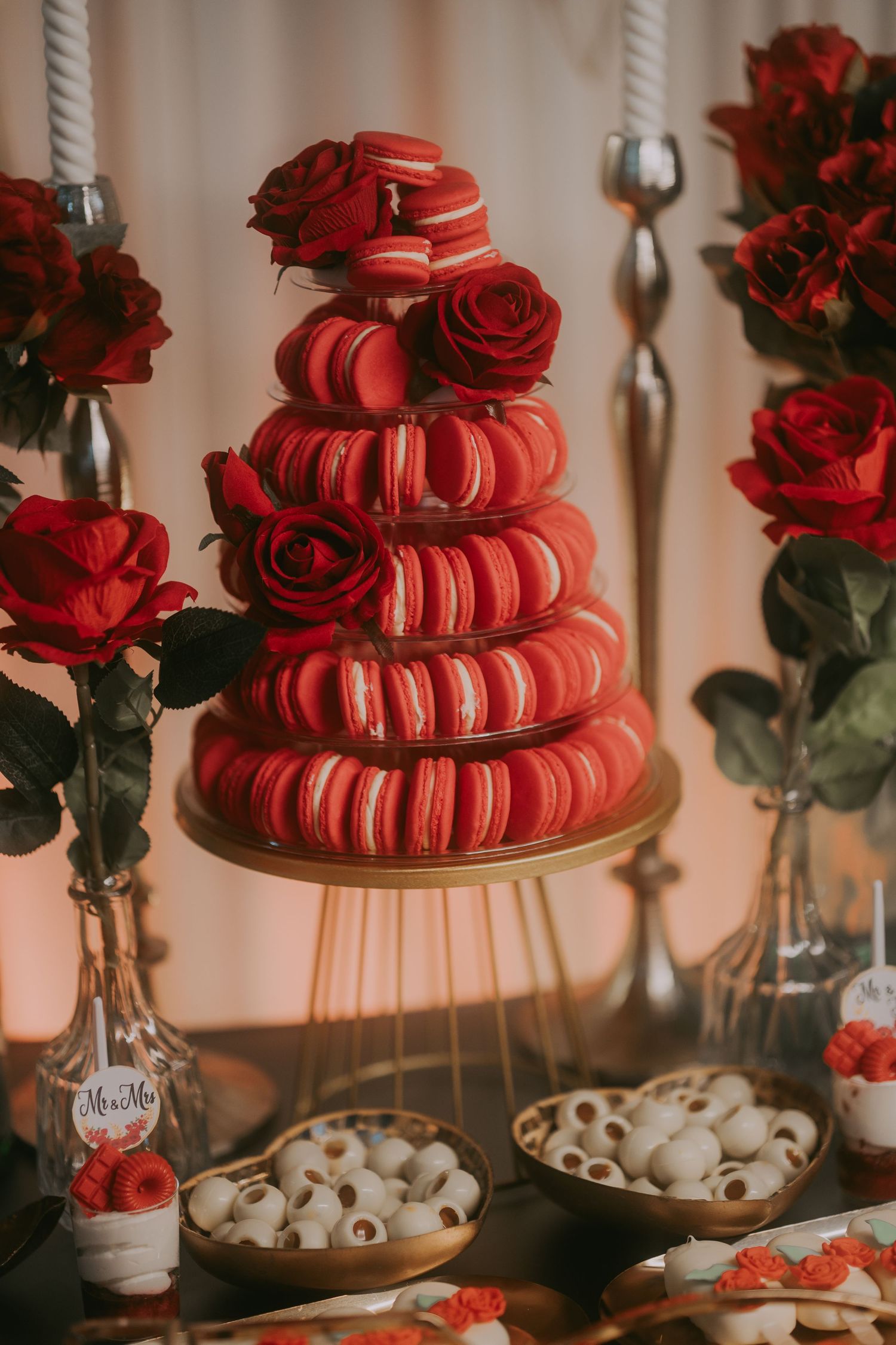 Stunning red macaron tower centerpiece surrounded by roses and white chocolate truffles at wedding. Epicu Fotograf Drobeta-Turnu Severin