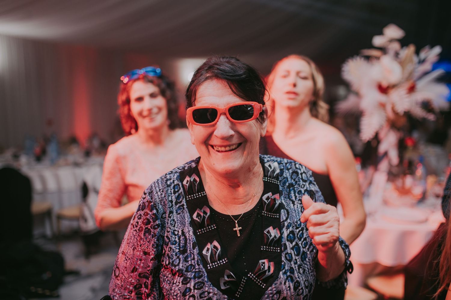 Elderly woman smiling in red sunglasses enjoying a festive wedding reception celebration. Epicu Fotograf Drobeta-Turnu Severin