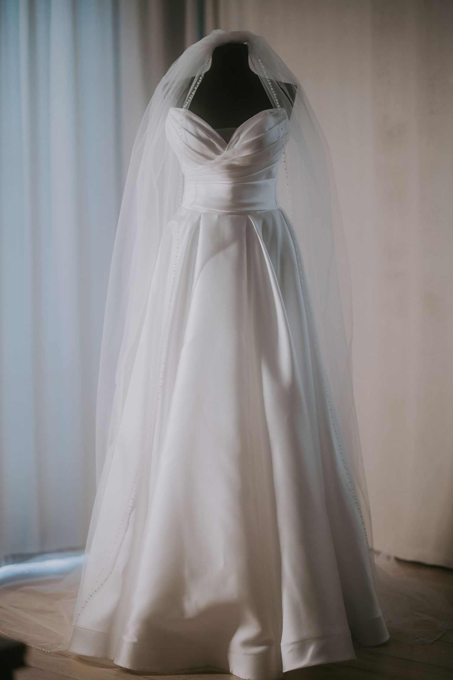 Elegant white strapless ball gown wedding dress with flowing veil displayed on a mannequin. Epicu Fotograf Drobeta-Turnu Severin
