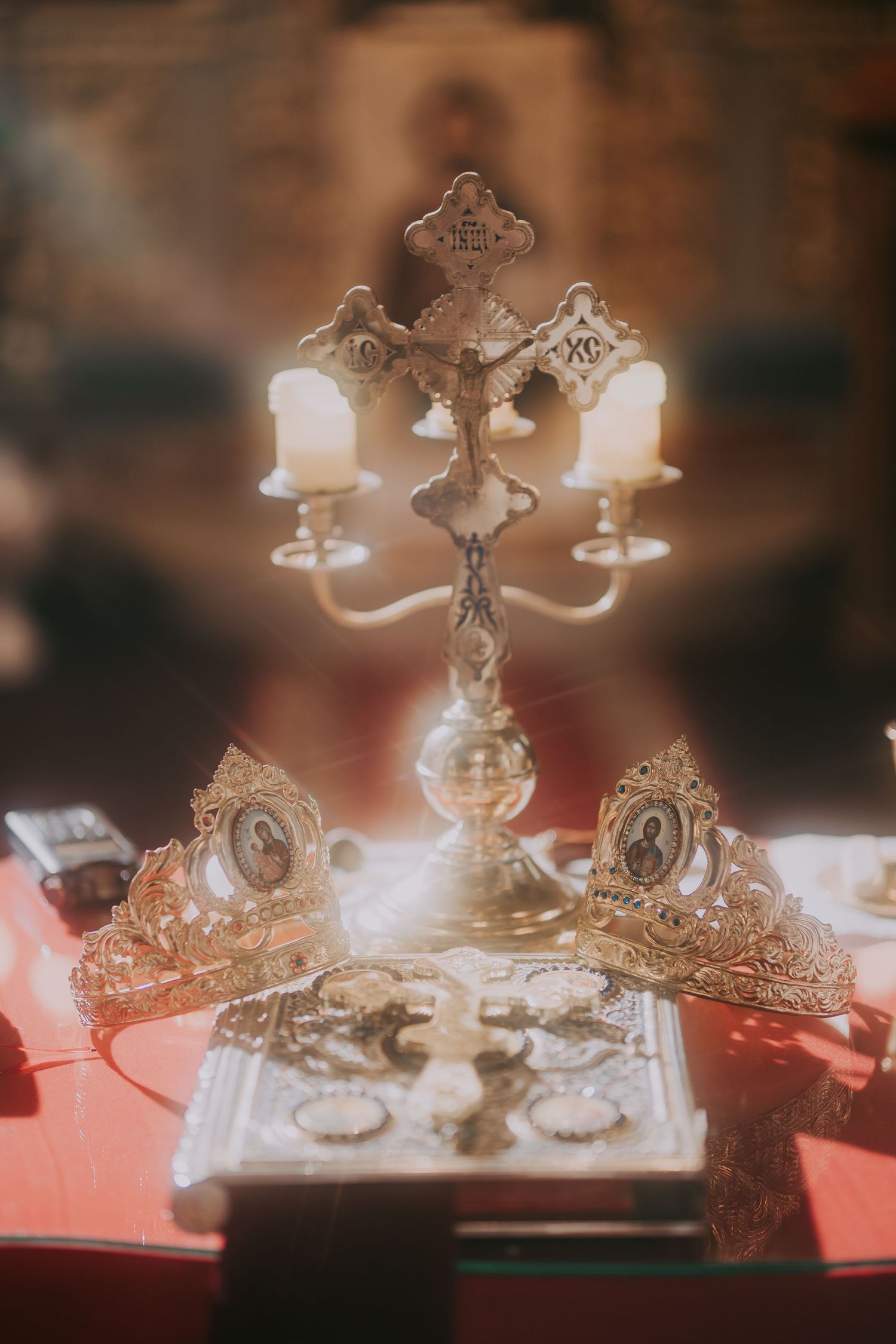 Ornate silver Orthodox wedding cross candelabra with crowns and holy book on a red altar. Epicu Fotograf Drobeta-Turnu Severin