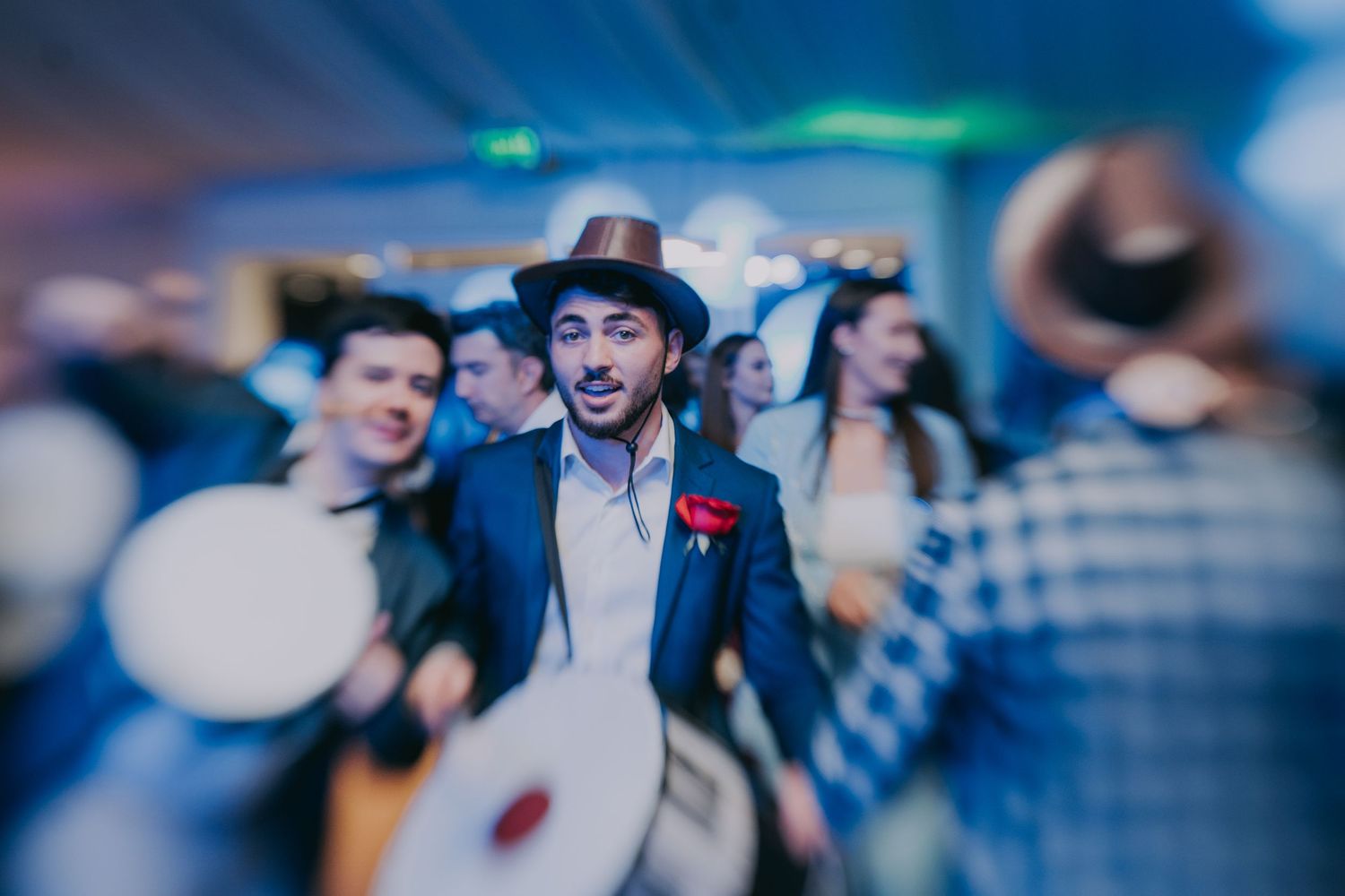 Musician in brown hat performing energetically at a wedding reception party with guests. Epicu Fotograf Drobeta-Turnu Severin