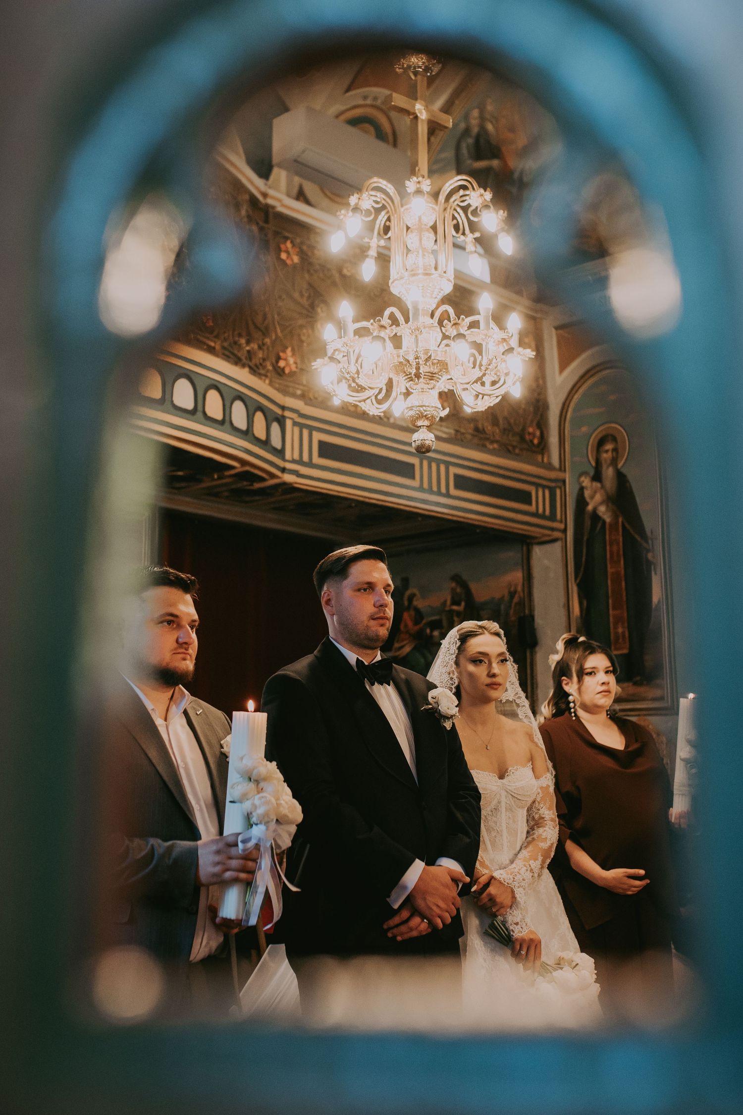 Bride and groom reflected in mirror during Orthodox church wedding.