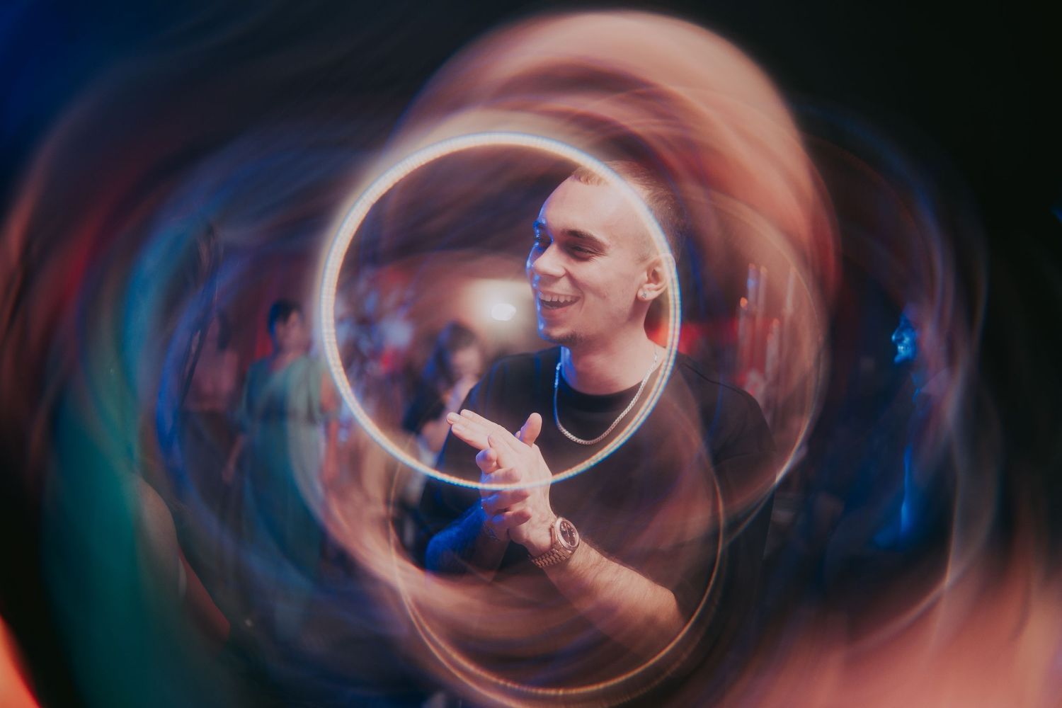 Artistic swirling long-exposure portrait of a bald man gesturing at a vibrant wedding celebration. Epicu Fotograf Drobeta-Turnu Severin