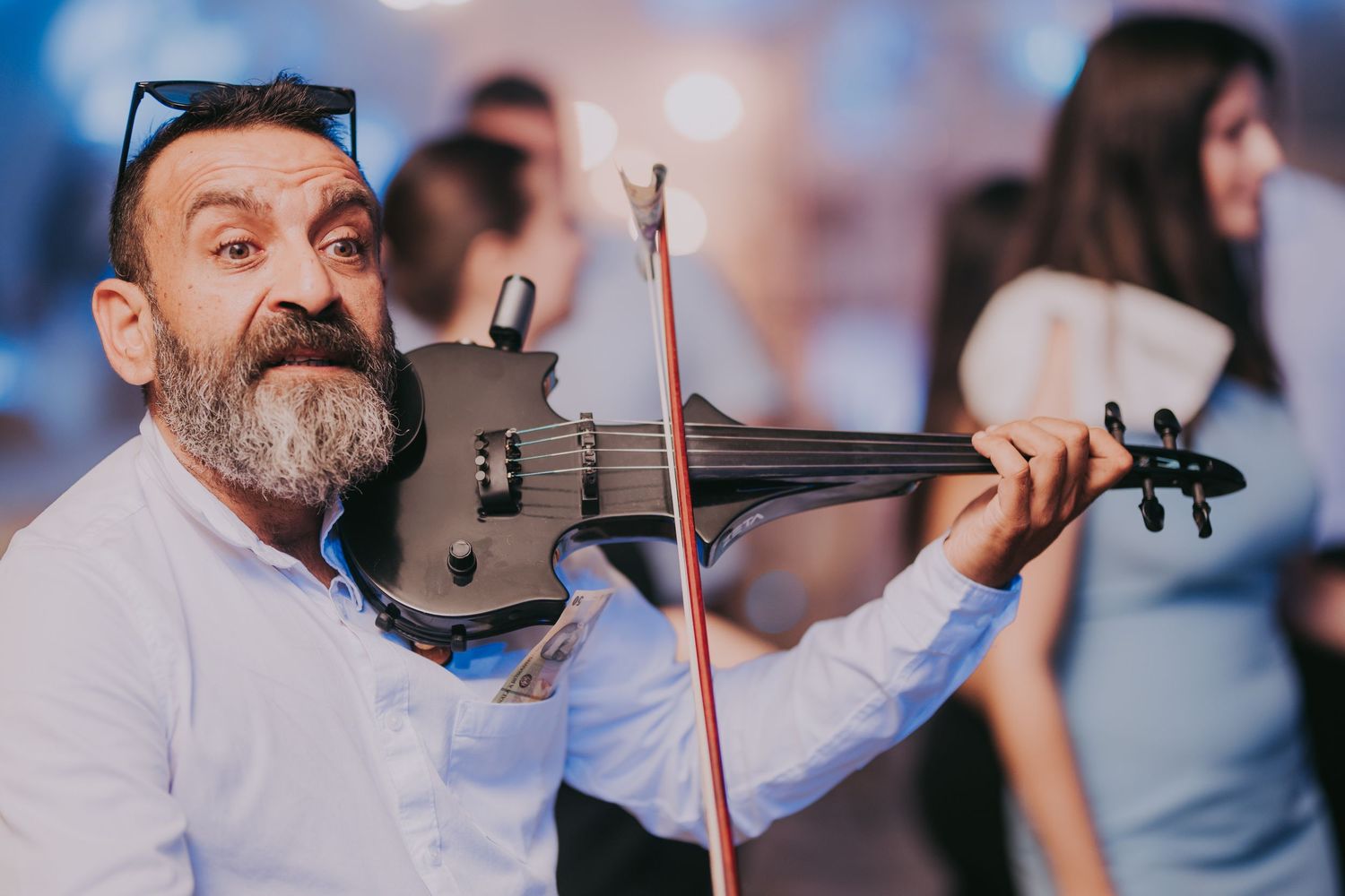 Bearded violinist plays a black electric violin with a red bow at an elegant wedding reception. Epicu Fotograf Drobeta-Turnu Severin