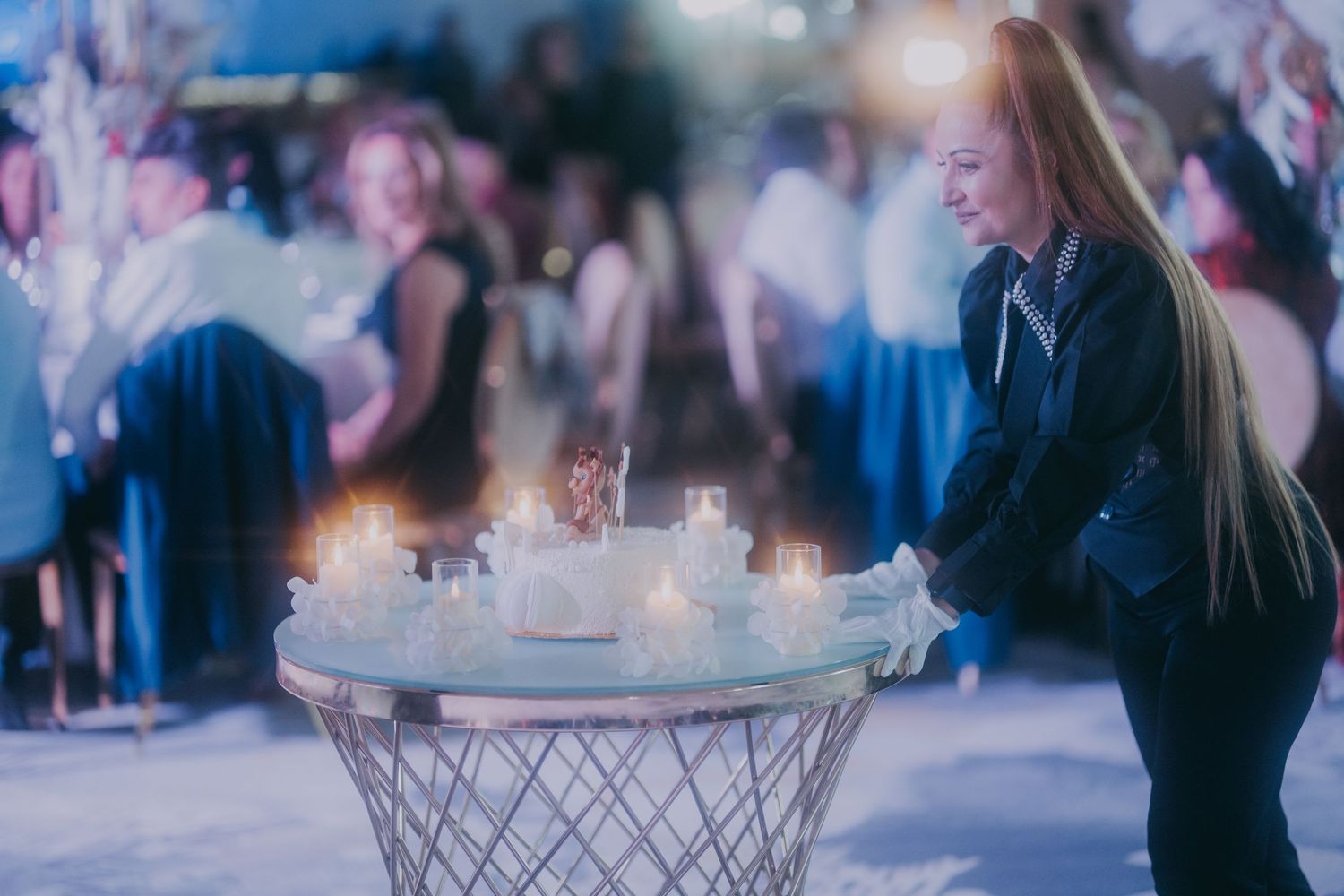 Woman in black jacket leans over glass table with candles at a wedding reception. Epicu Fotograf Drobeta-Turnu Severin