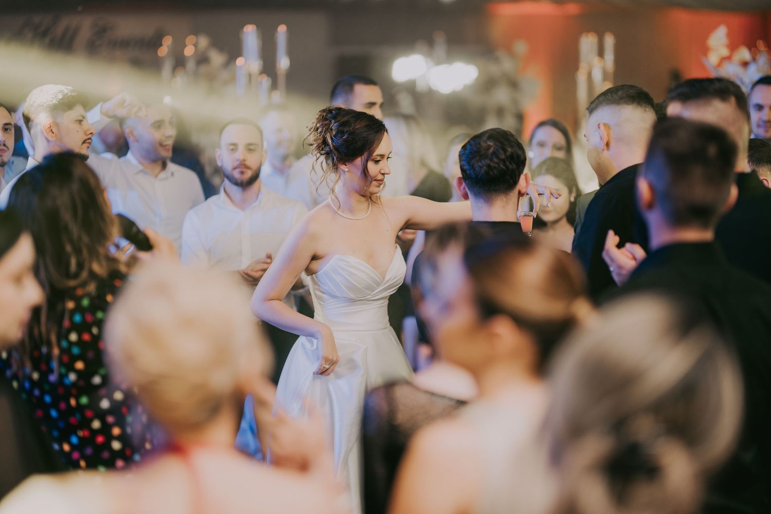 Bride in strapless white gown dances and smiles among guests at a lively wedding reception. Epicu Fotograf Drobeta-Turnu Severin