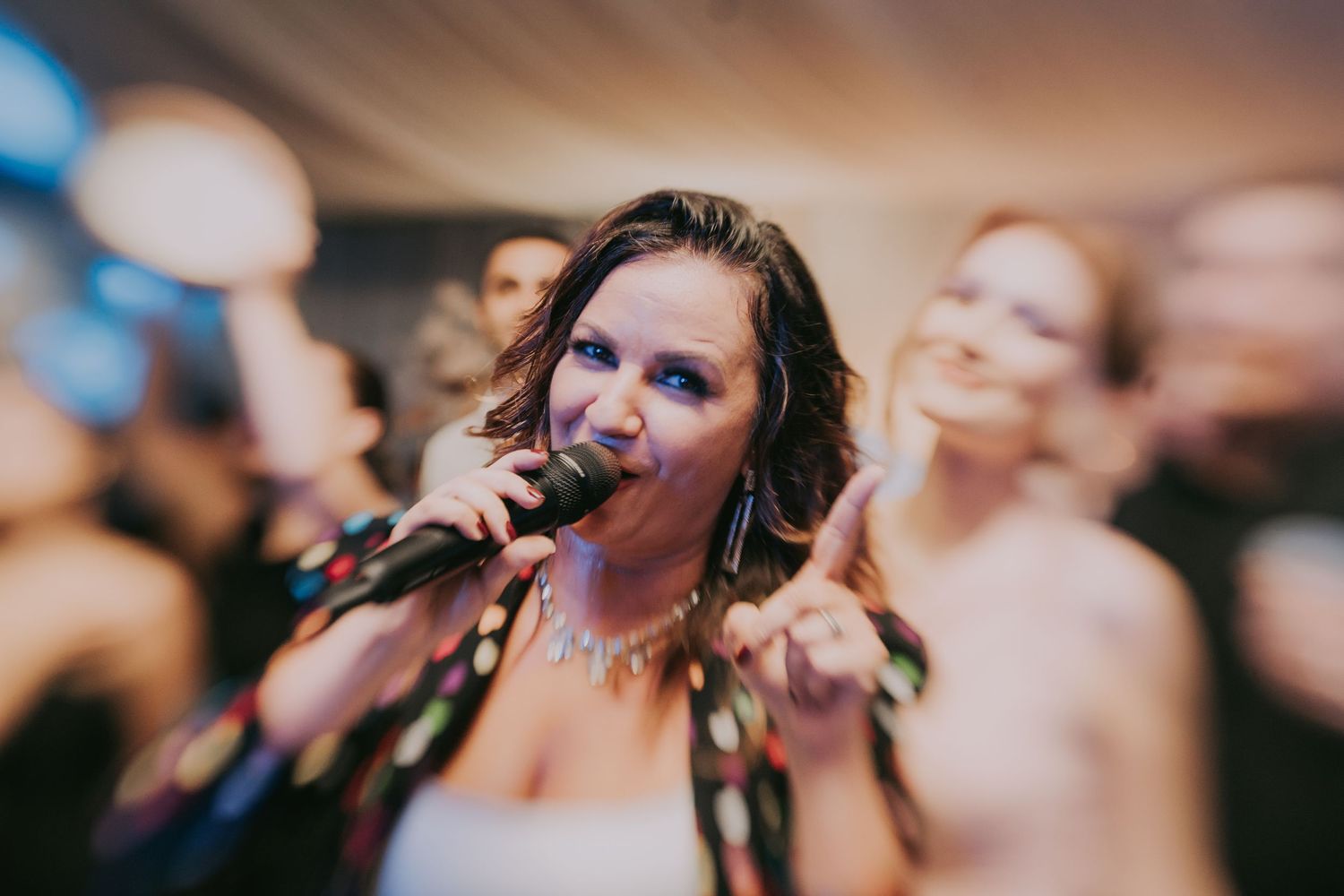 Woman singing passionately into microphone at a vibrant wedding reception celebration. Epicu Fotograf Drobeta-Turnu Severin