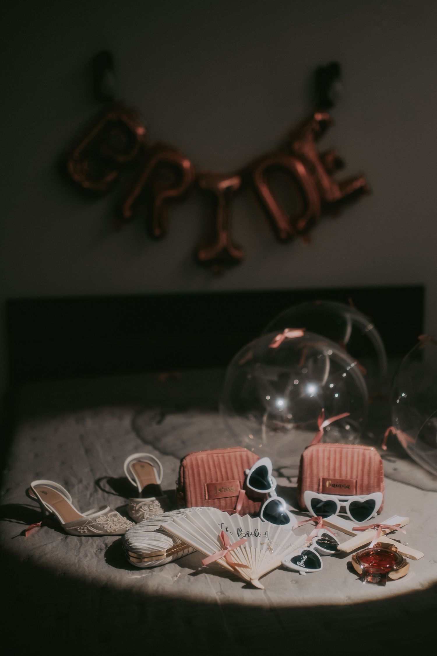 Bride party accessories including heels, sunglasses, and purses on bed with BRIDE balloon banner. Epicu Fotograf Drobeta-Turnu Severin