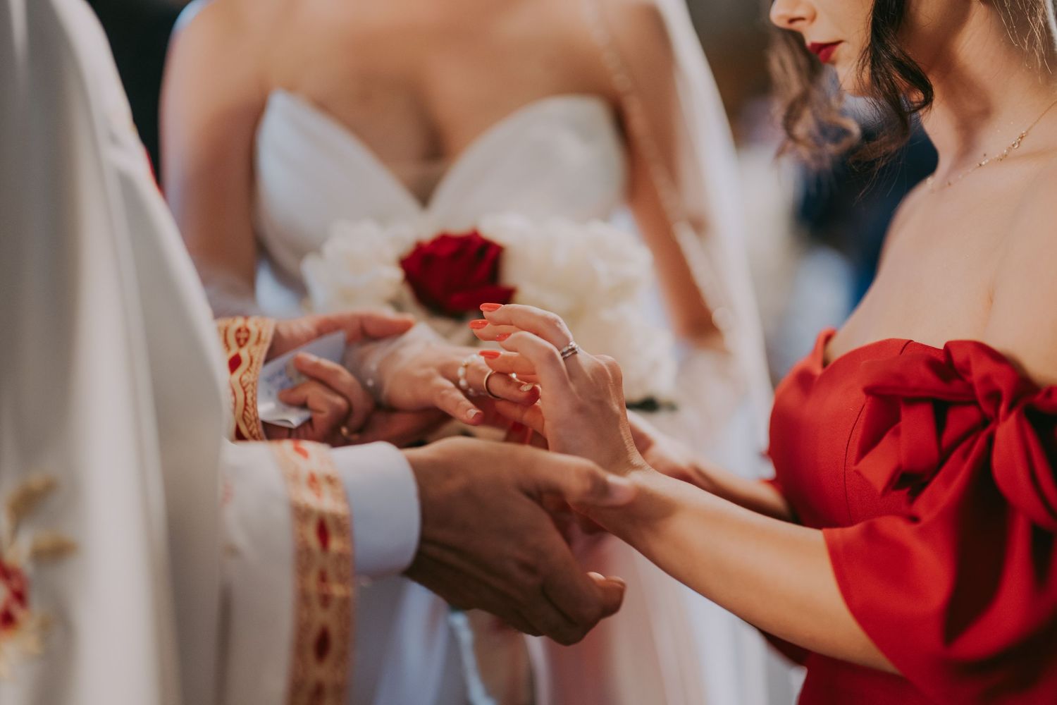 Orthodox priest exchanges wedding rings during elegant church ceremony with bride and bridesmaid present. Epicu Fotograf Drobeta-Turnu Sever