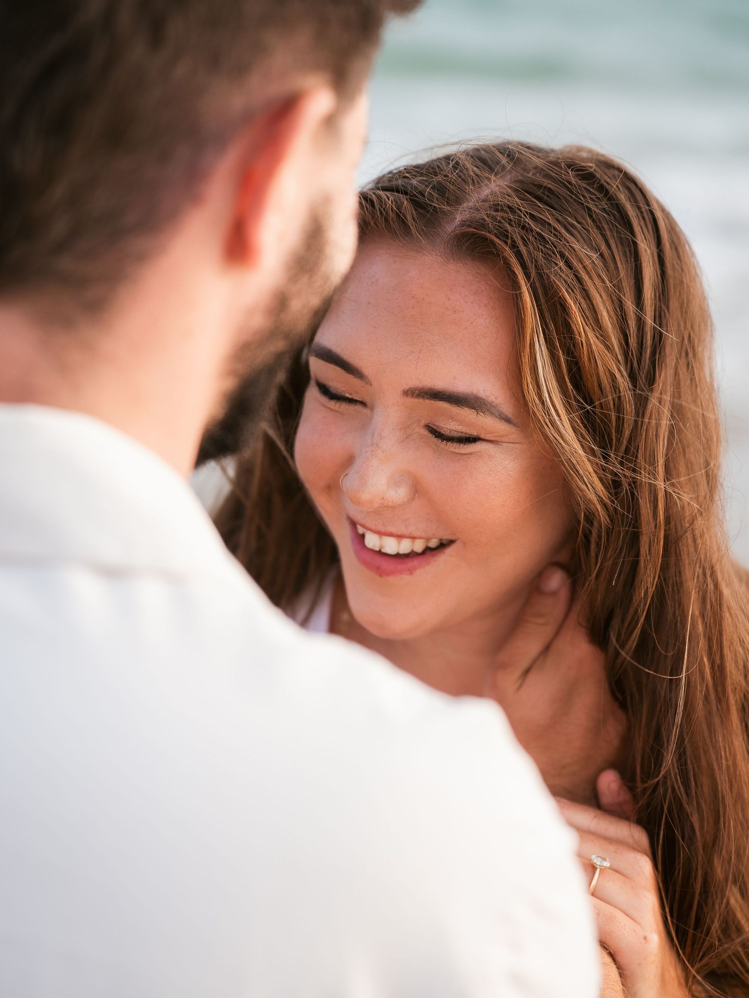 Woman laughing being embraced by fiance