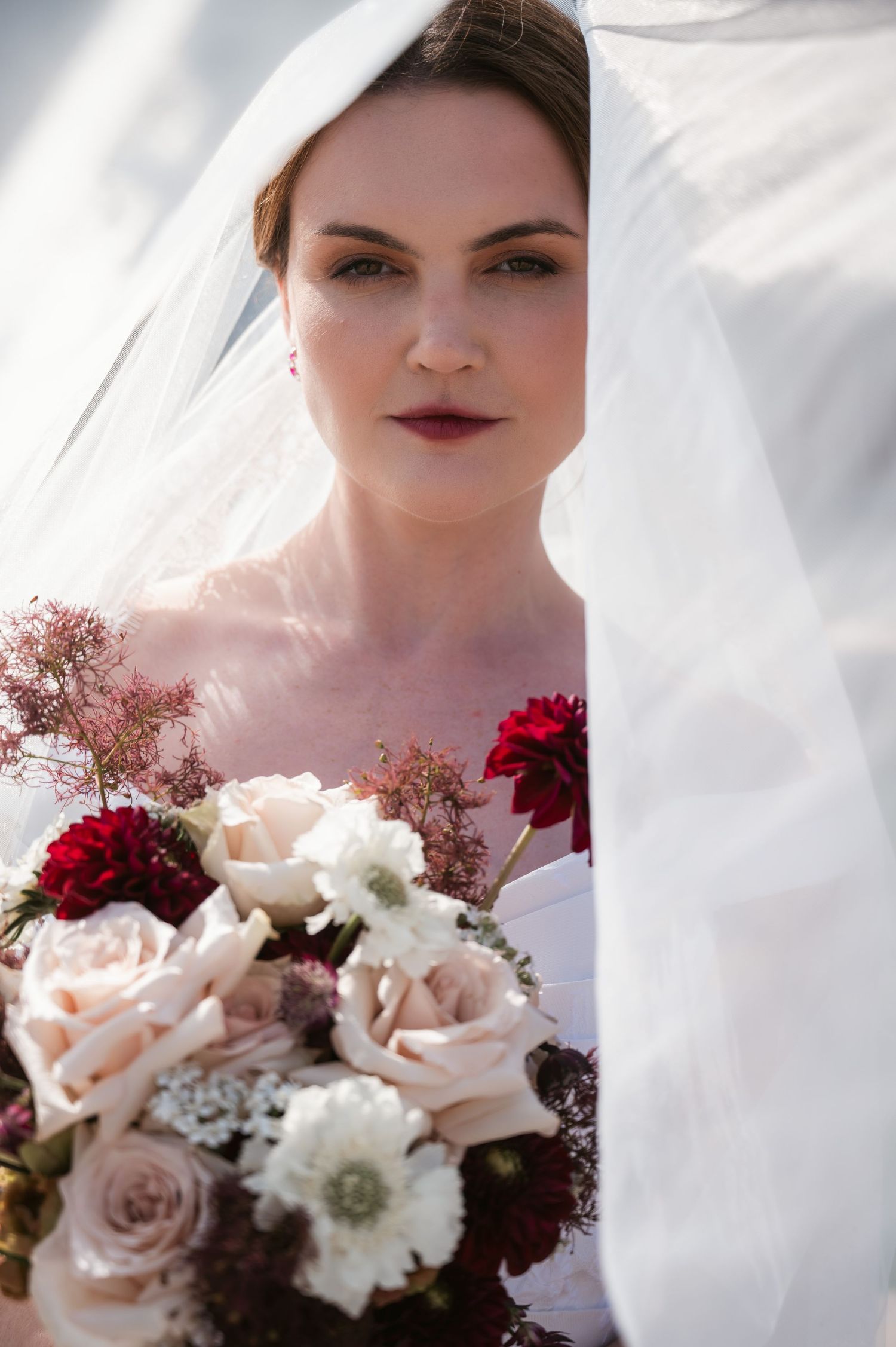 Stunning bridal veil portrait holding bouquet