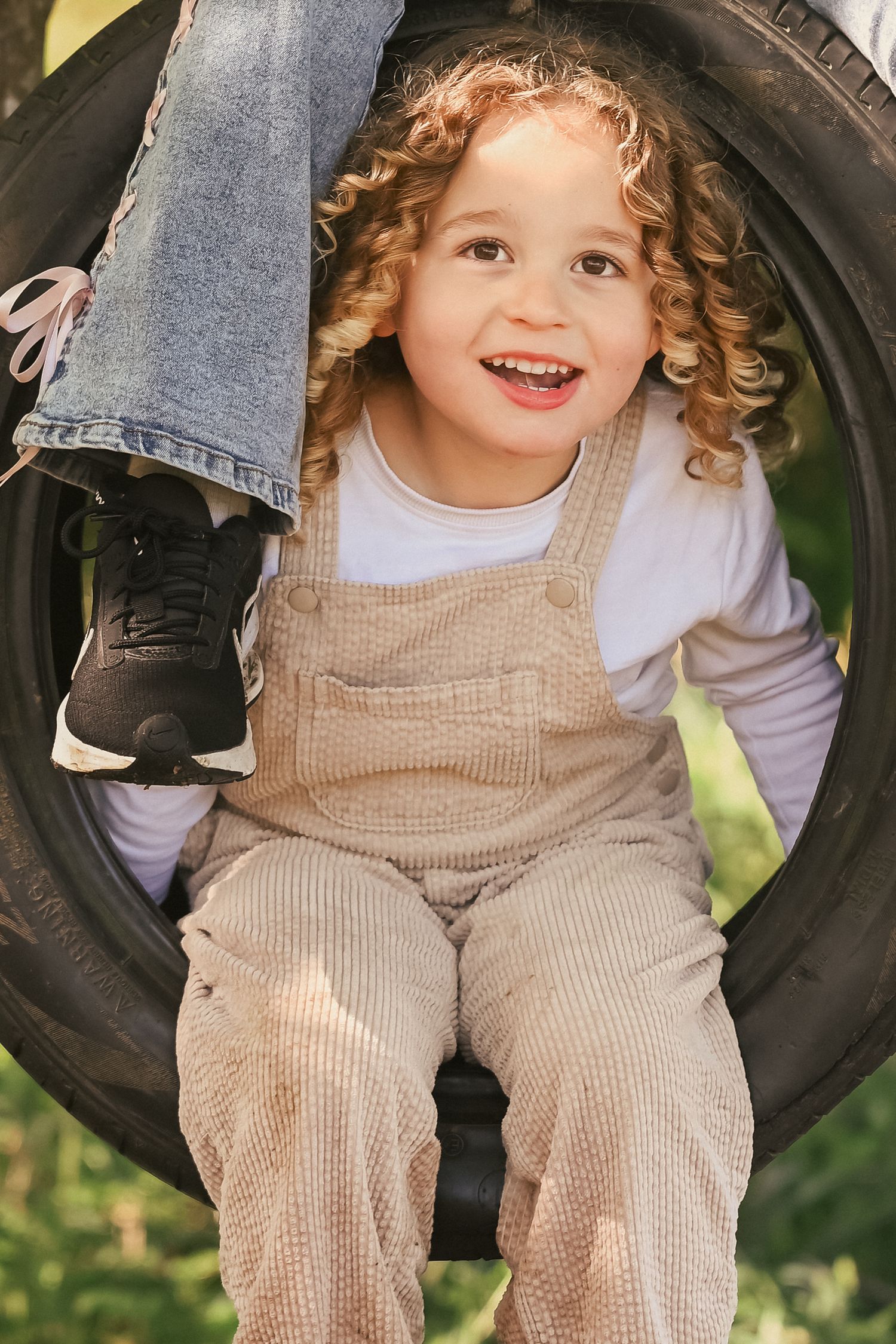 Toddler in tyre swing smiling