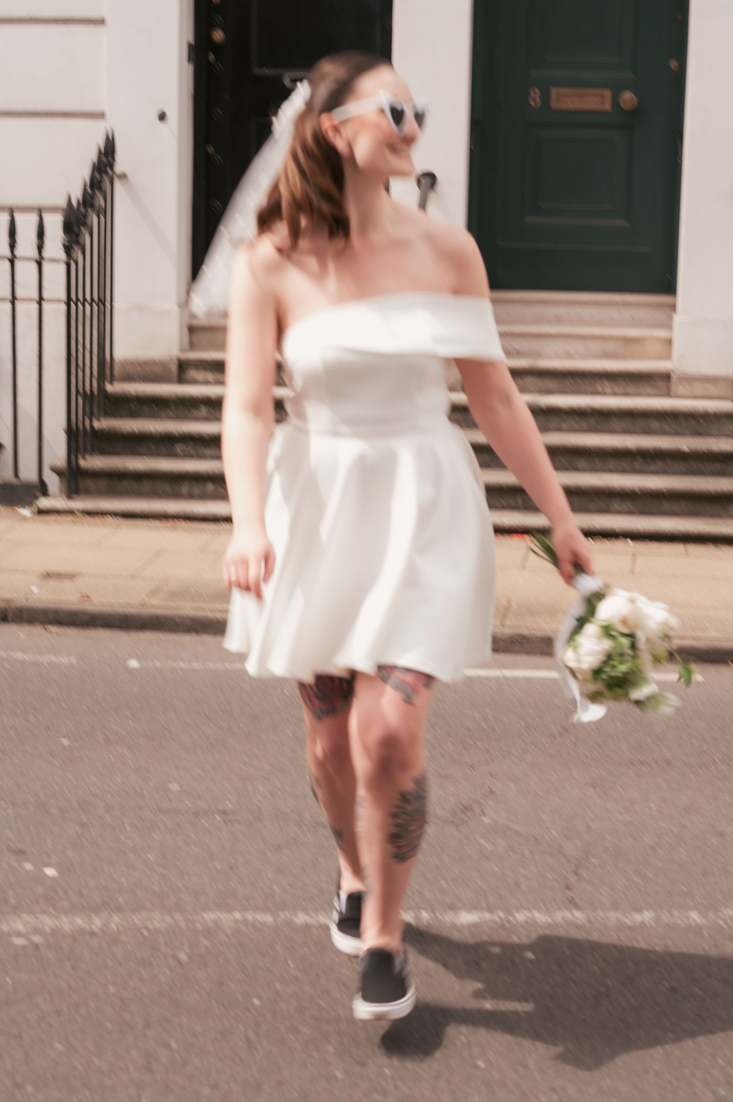 bride in city in mini dress and vans crossing the street, blur motion