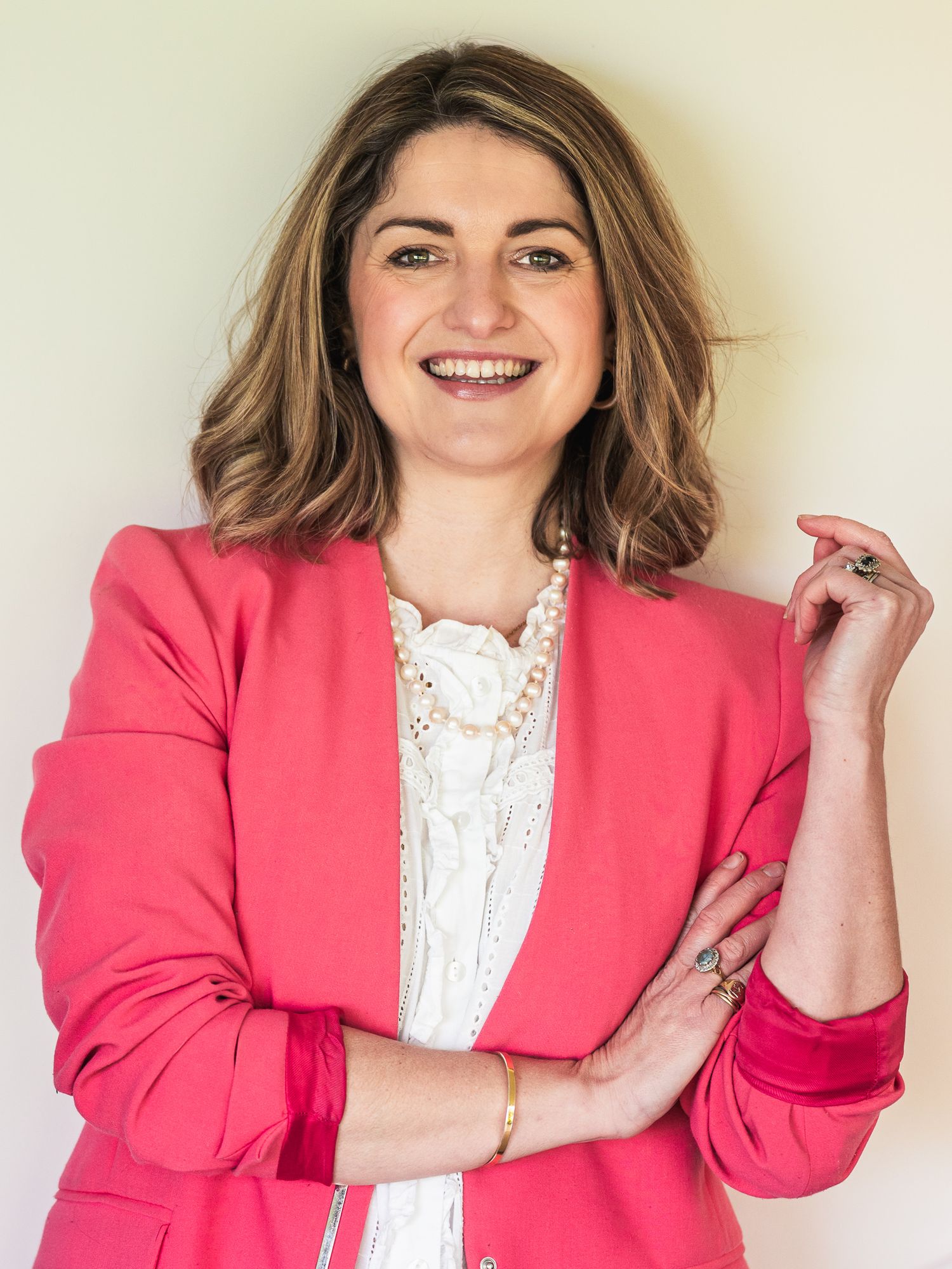 Headshot of therapist smiling looking at the camera, wearing a bright pink blazer