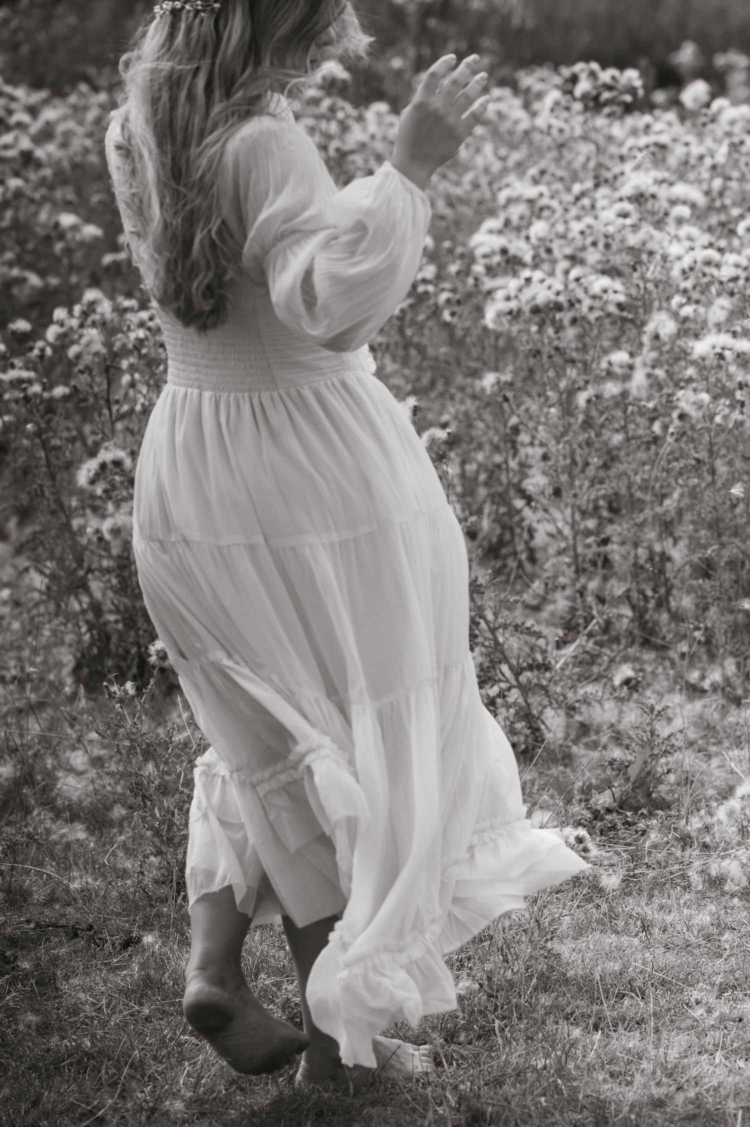 Editorial of woman twirling bare foot in a field