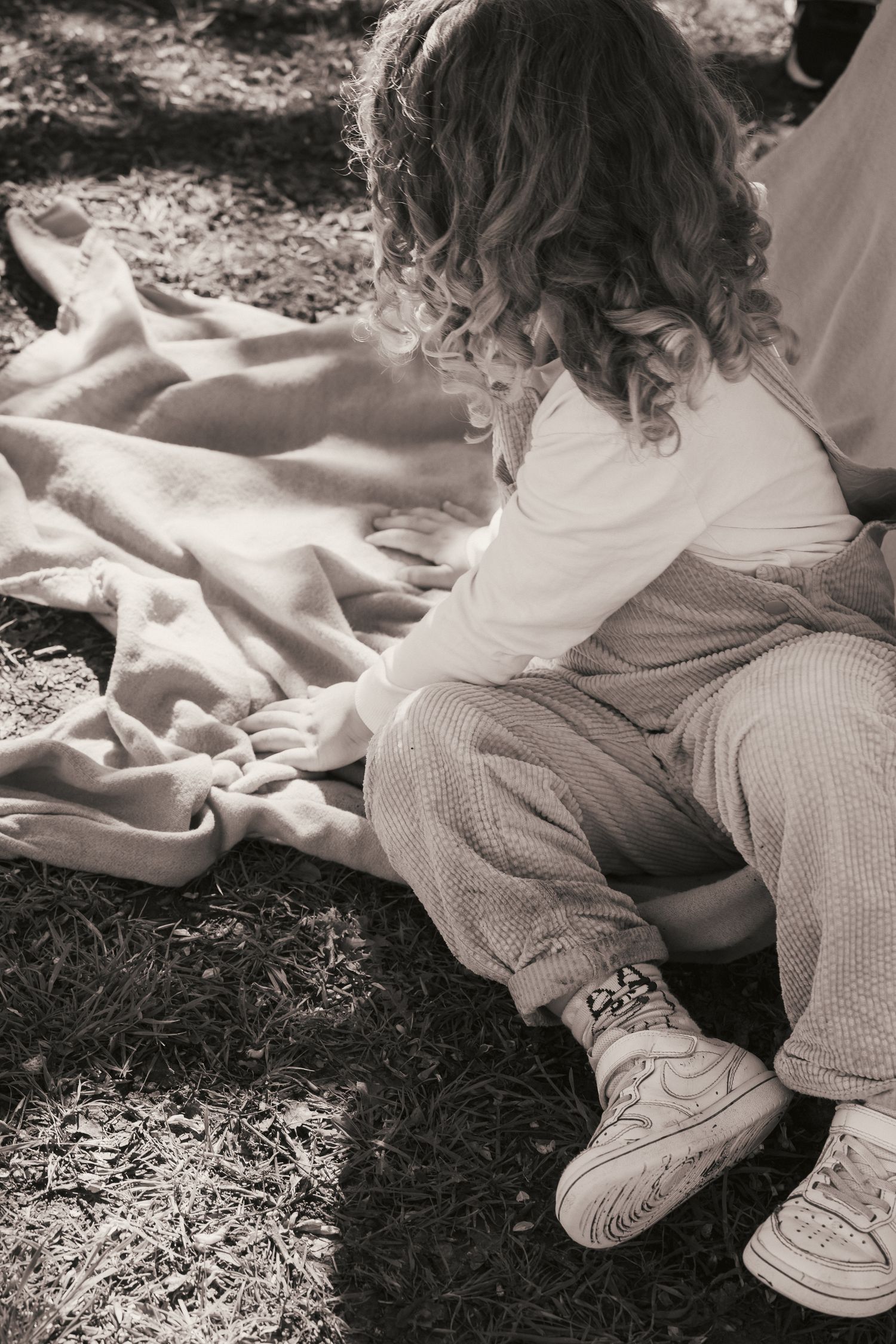 toddler on blanket looking away from camera