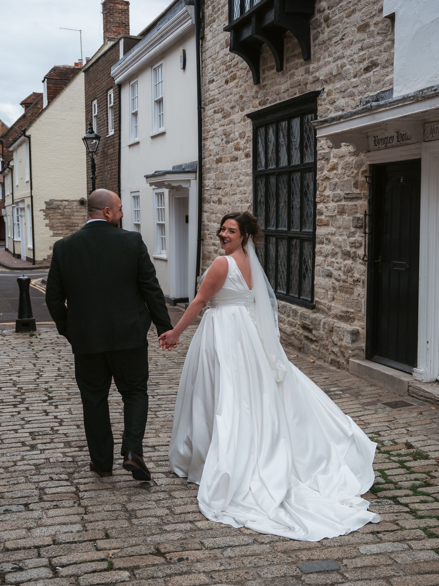 Bride and groom portrait walking down cobbled street