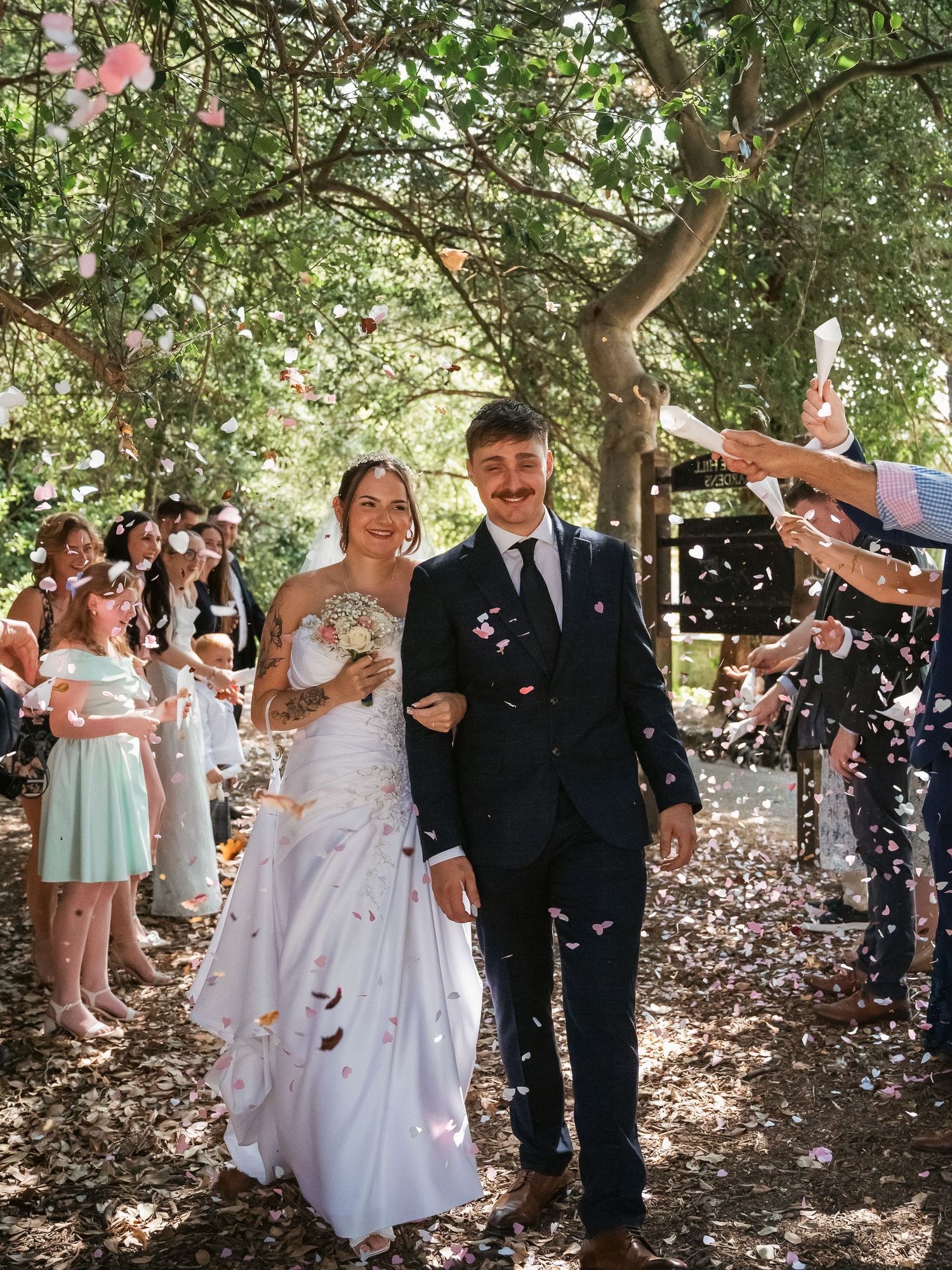 Confetti shot of a newly wed couple through the trees