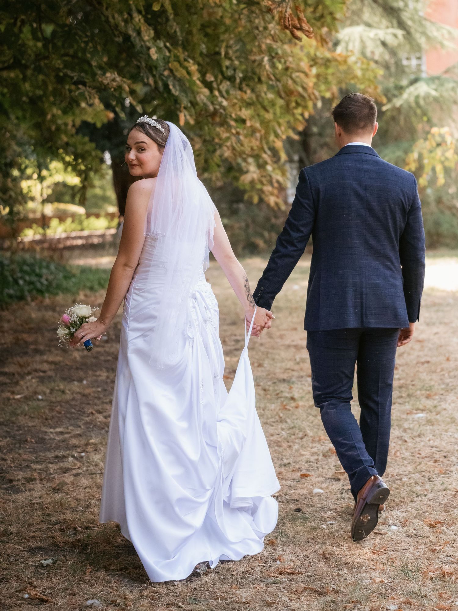 Newly wed portrait walking away and looking back over shoulder