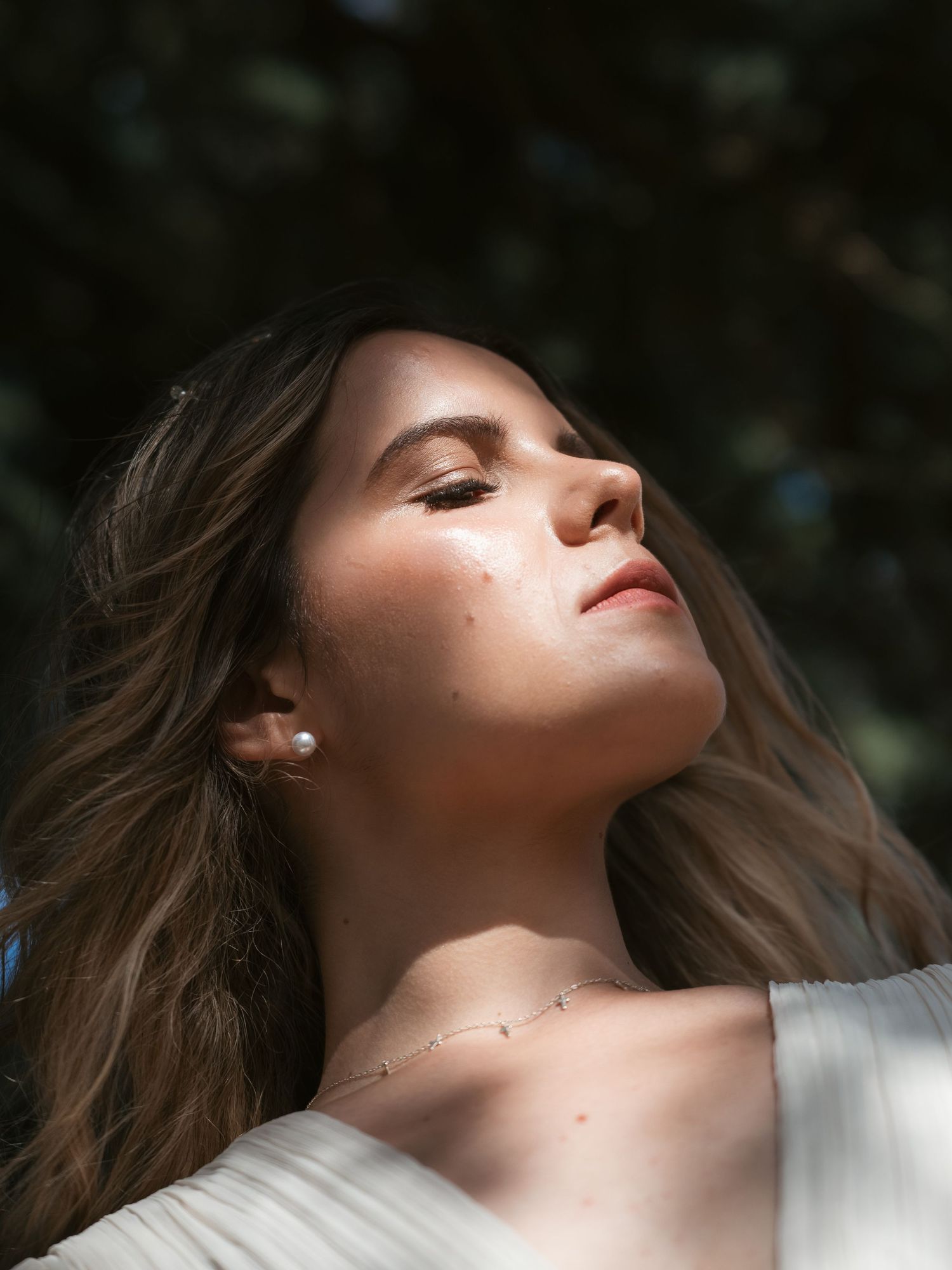 Editorial of woman amongst tree creating shadows across face