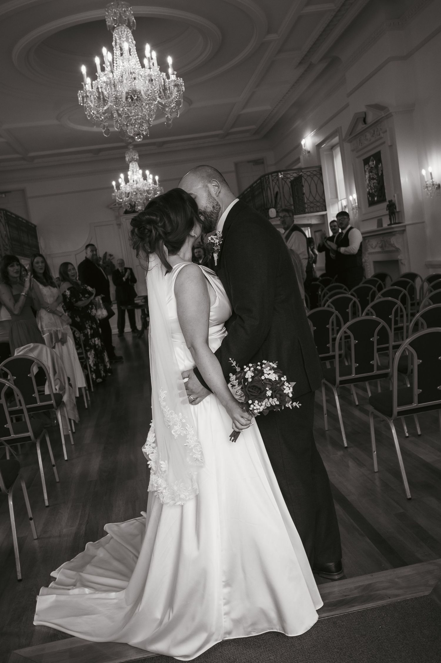 Bride and groom kissing at the end of the aisle