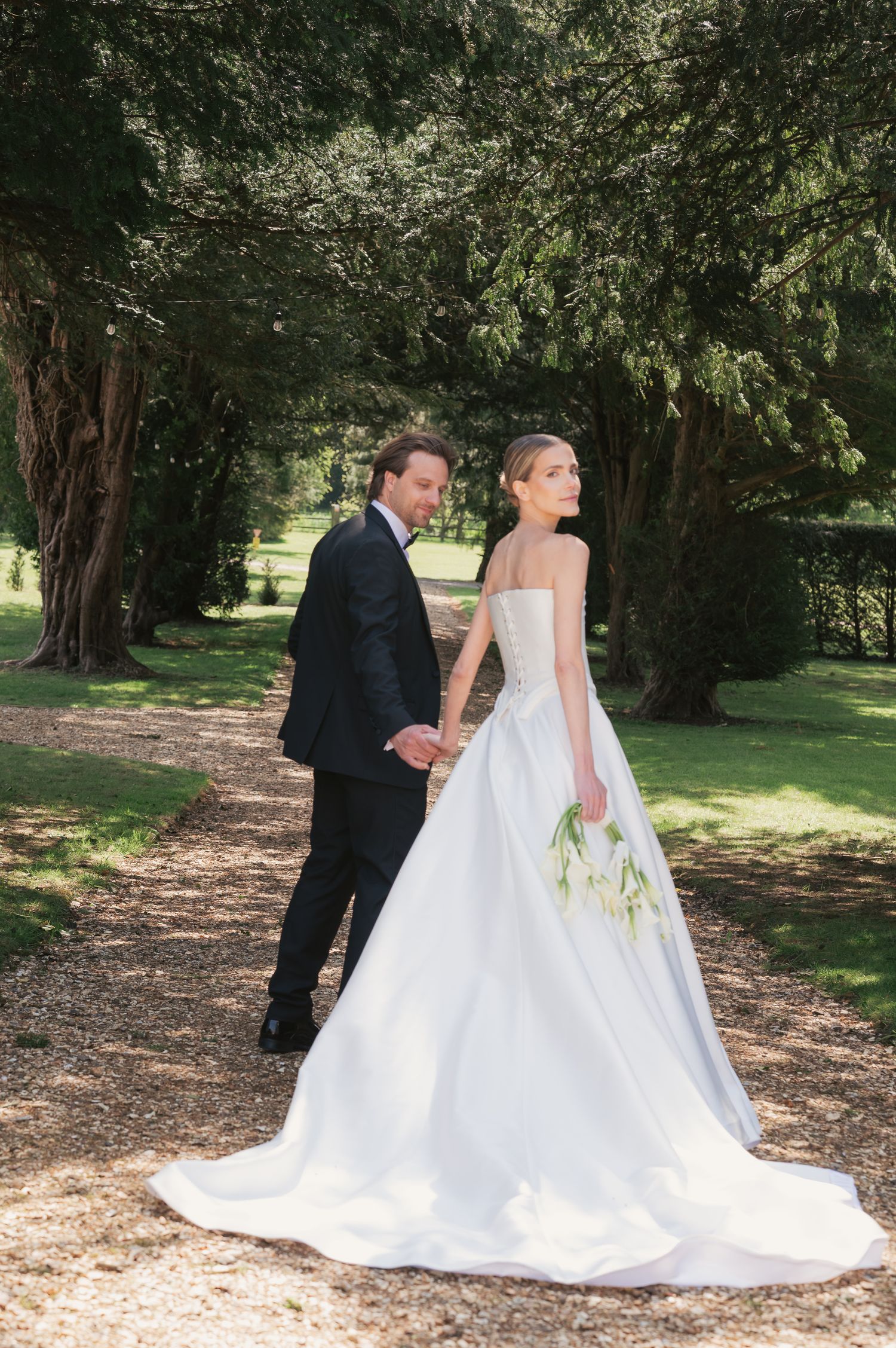 Bride looks back while walking along path