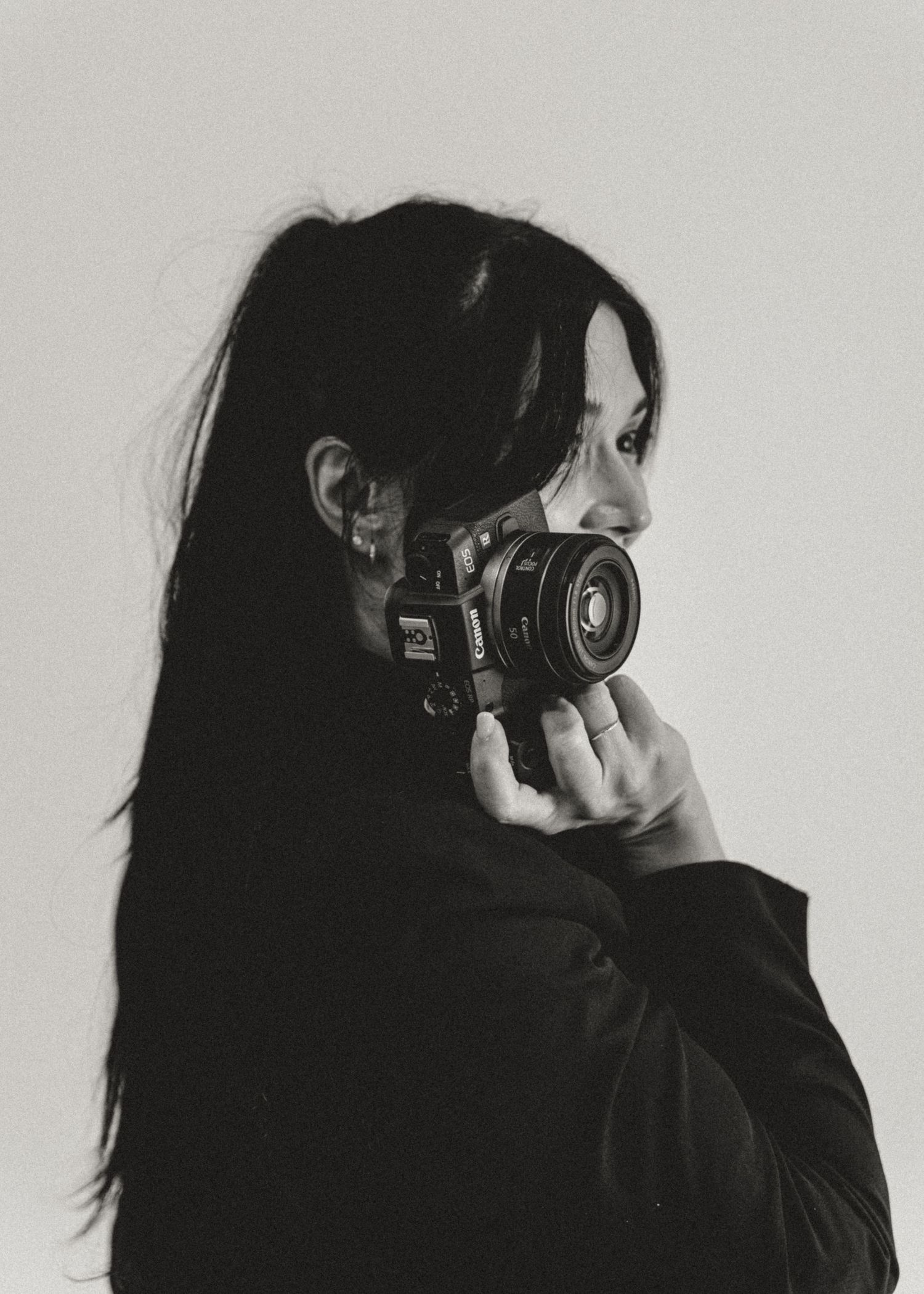 Black and white portrait of a woman holding a camera