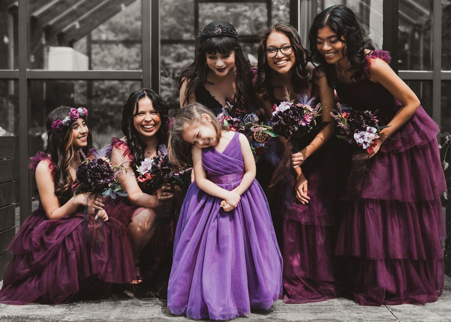 Group portrait of young women in colorful formal dresses with a girl in a purple dress
