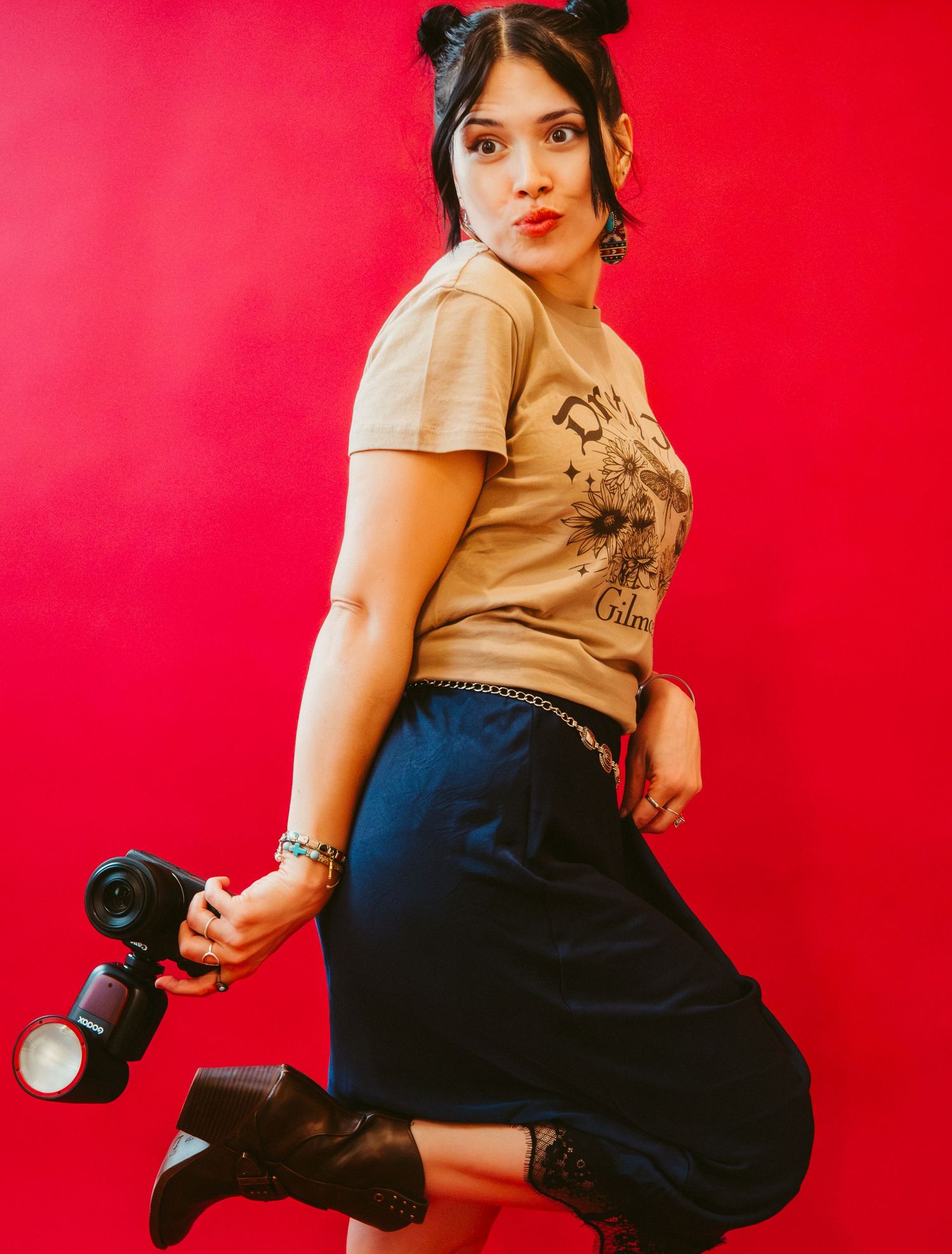 Editorial portrait of a woman standing against a vivid red background