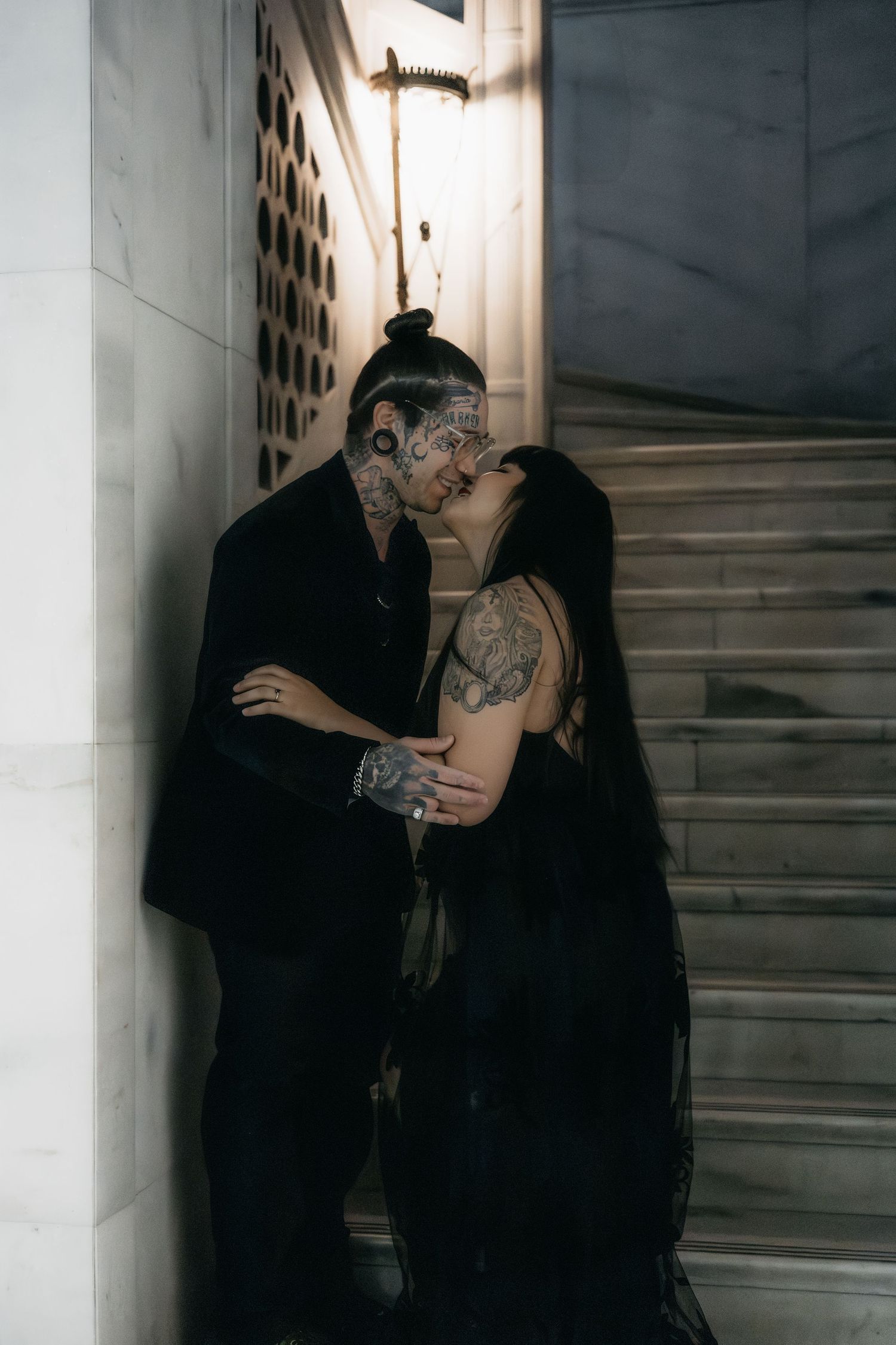 Dark editorial portrait of a couple embracing inside a historic building