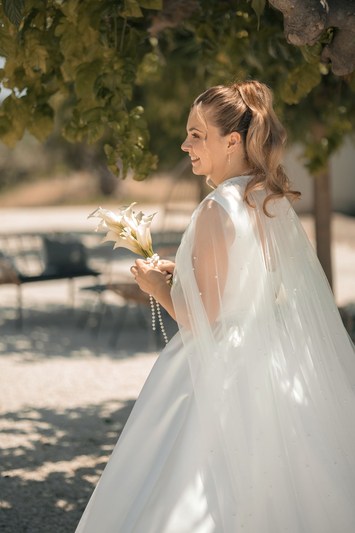 La mariée en cape de tulle dans le parc du Château Vannières