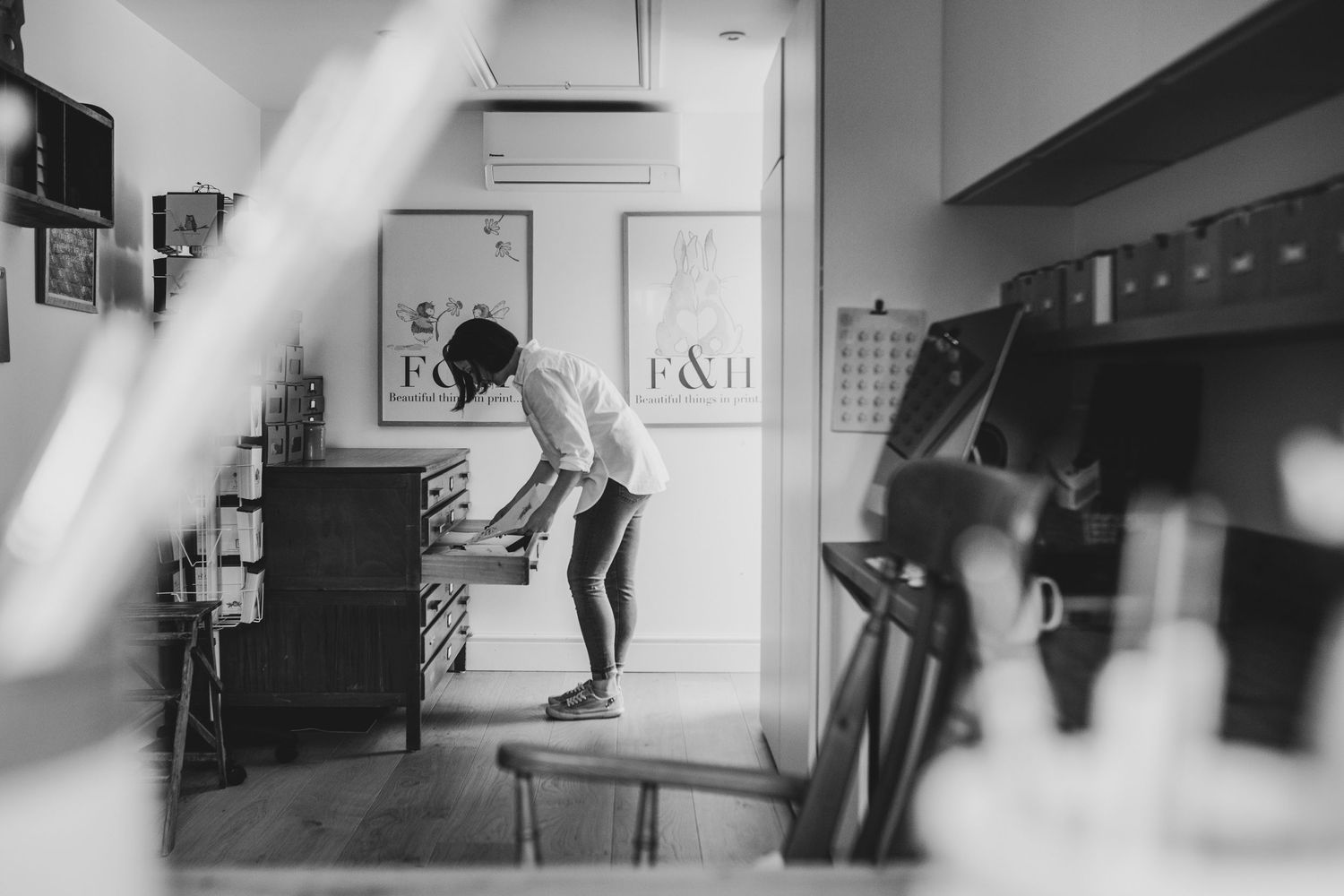 Black and white photo of person jumping inside a room.