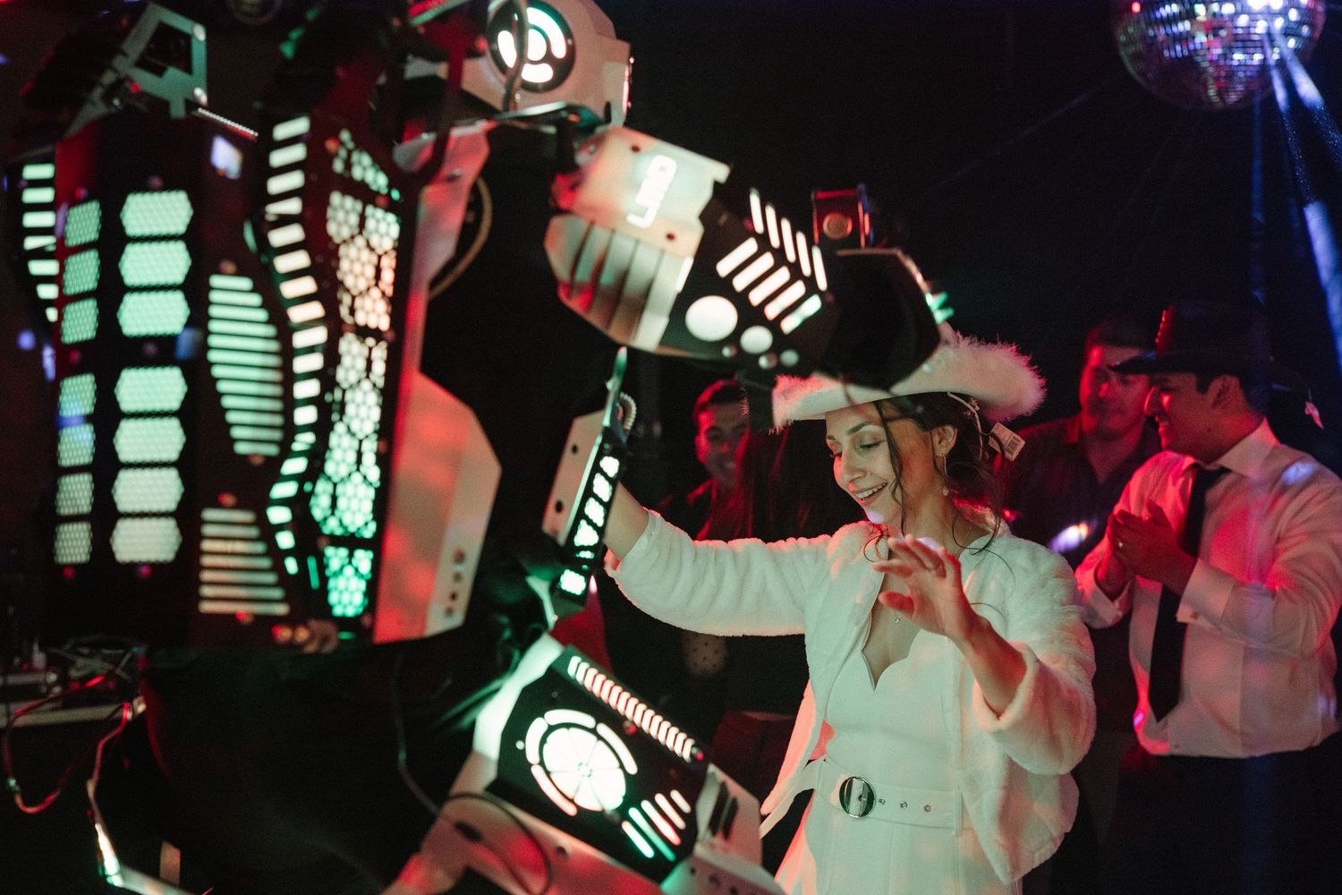 LED robot performer entertaining guests at a nighttime wedding reception.