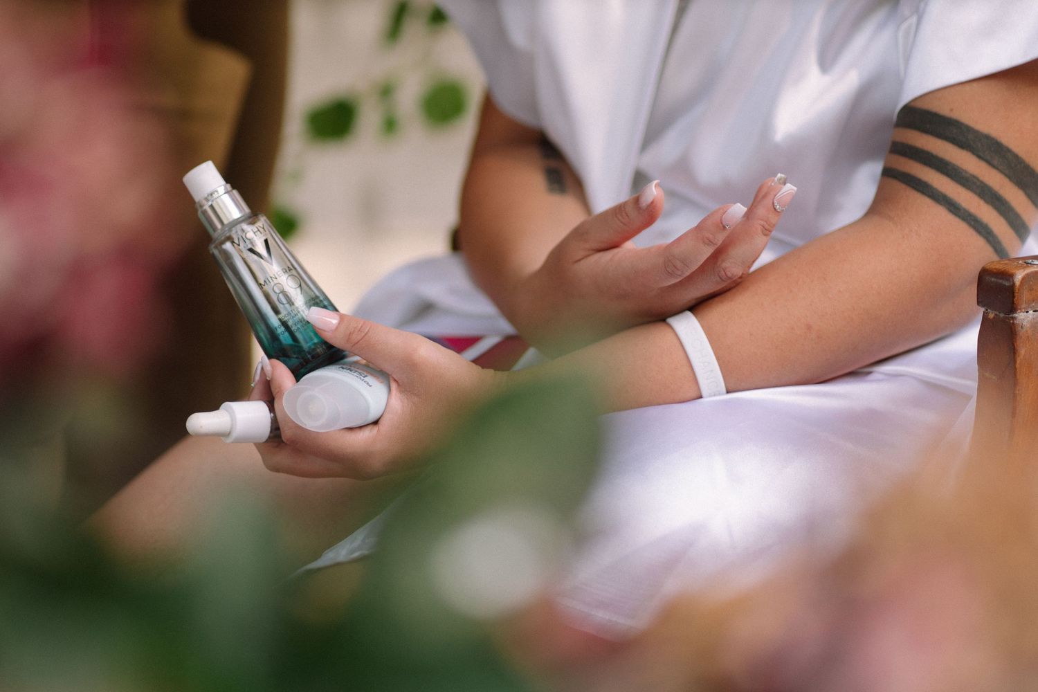 Close-up of hands holding makeup products during wedding preparation.