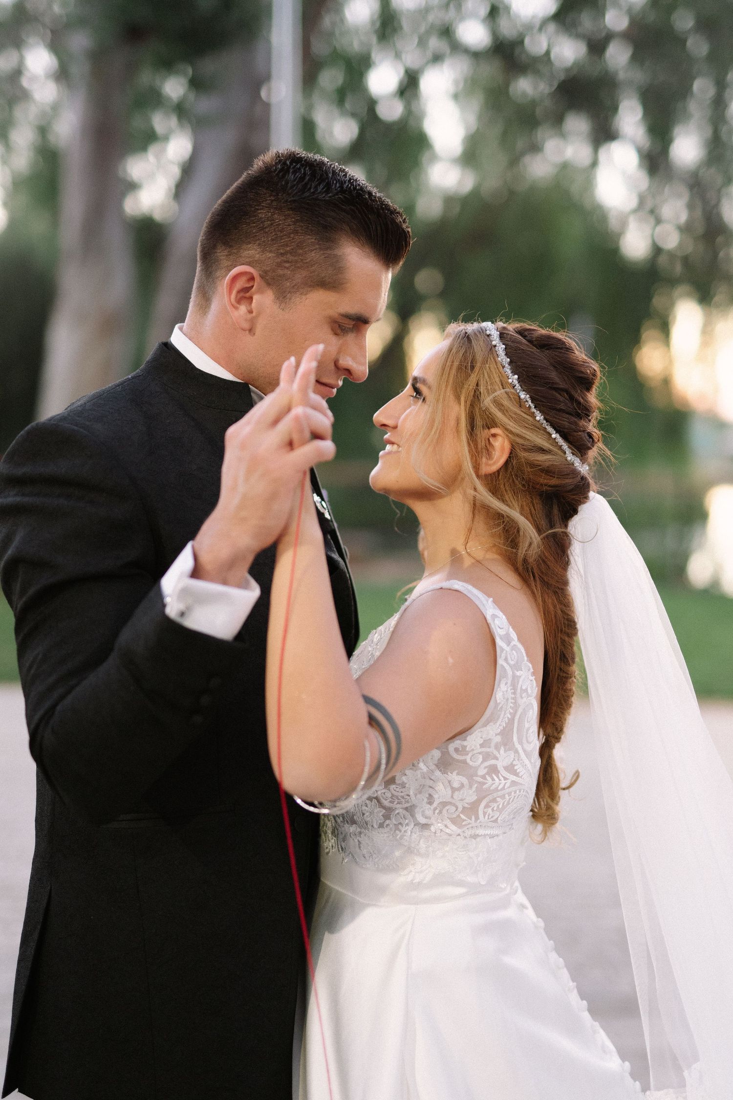 Newlyweds share an intimate moment while dancing together outdoors.
