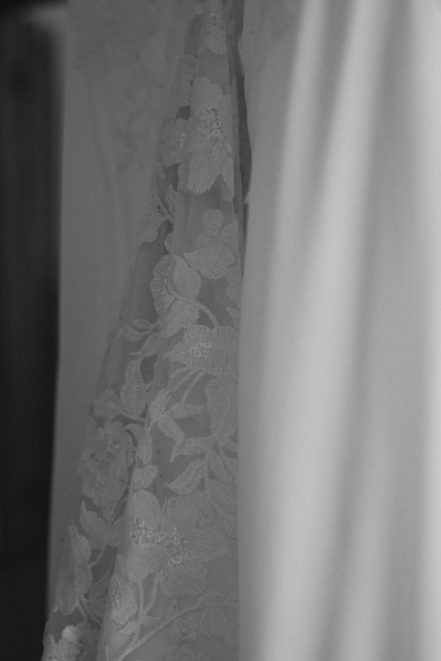 Close-up detail of lace patterns on a white wedding dress fabric.