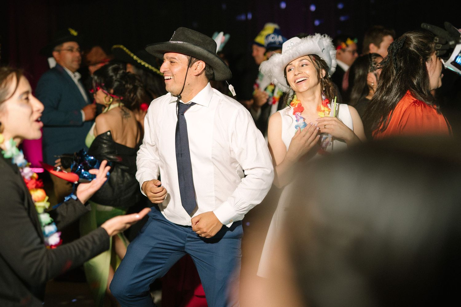 Party guests in western-style attire dancing energetically at a costume event.