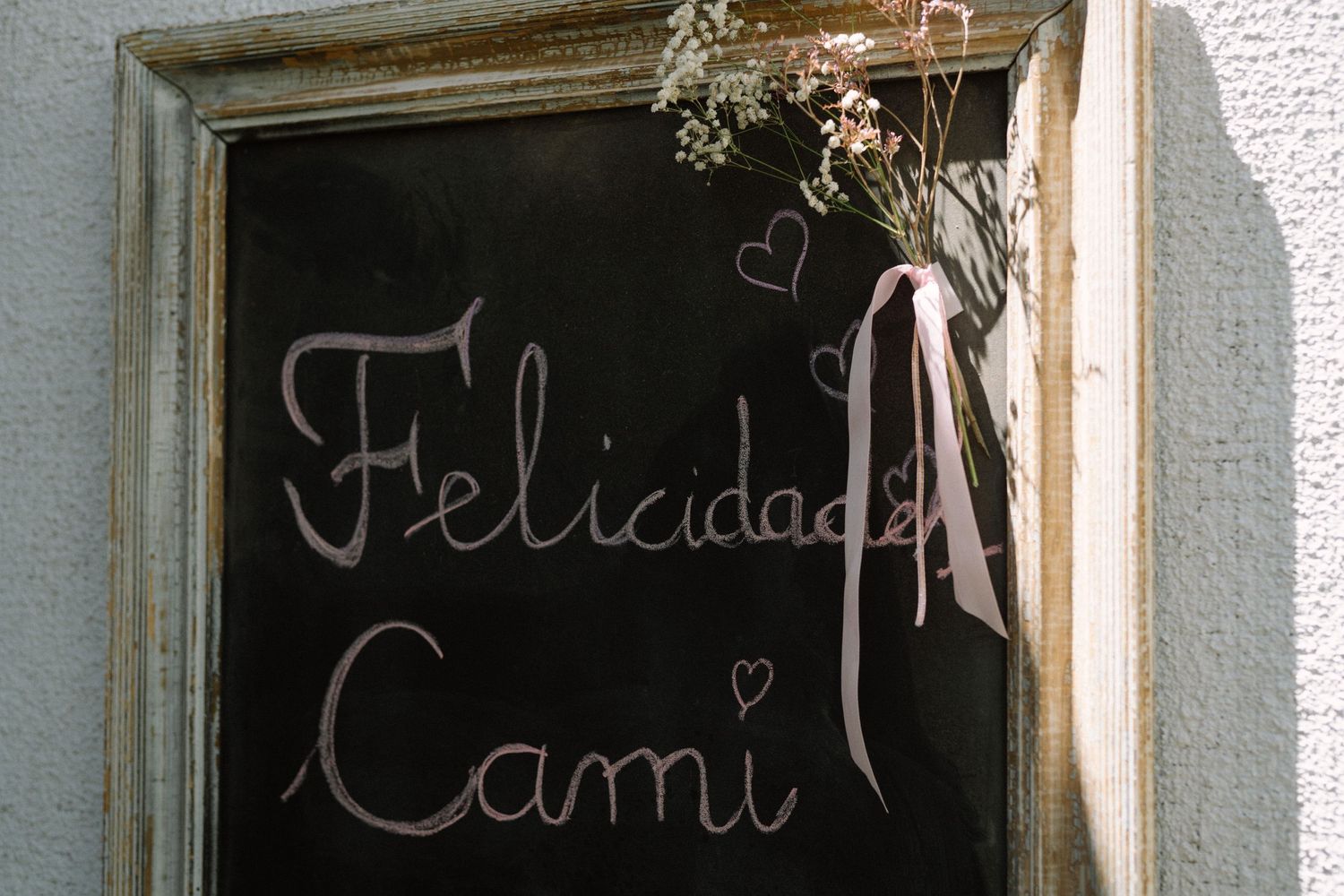 A chalkboard sign displaying congratulations message with decorative floral accents.