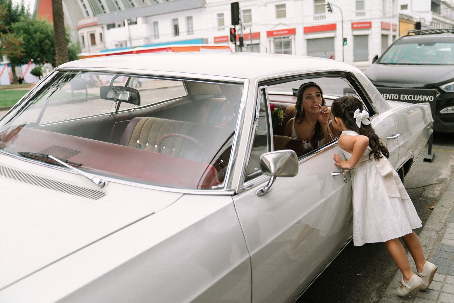 Classic white convertible car parked on a street with elegant styling details.
