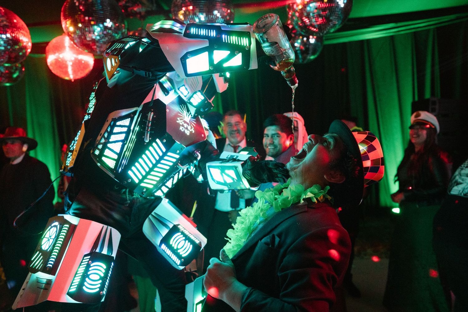 Futuristic LED robot performance with green lighting effects at a wedding reception.
