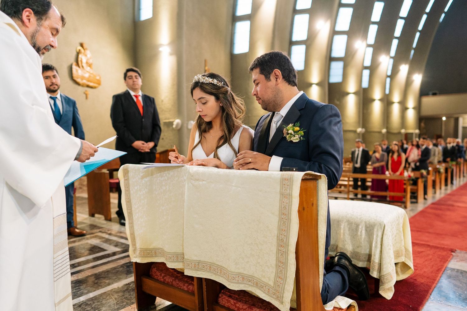 A couple signs their marriage certificate during a Catholic church ceremony.