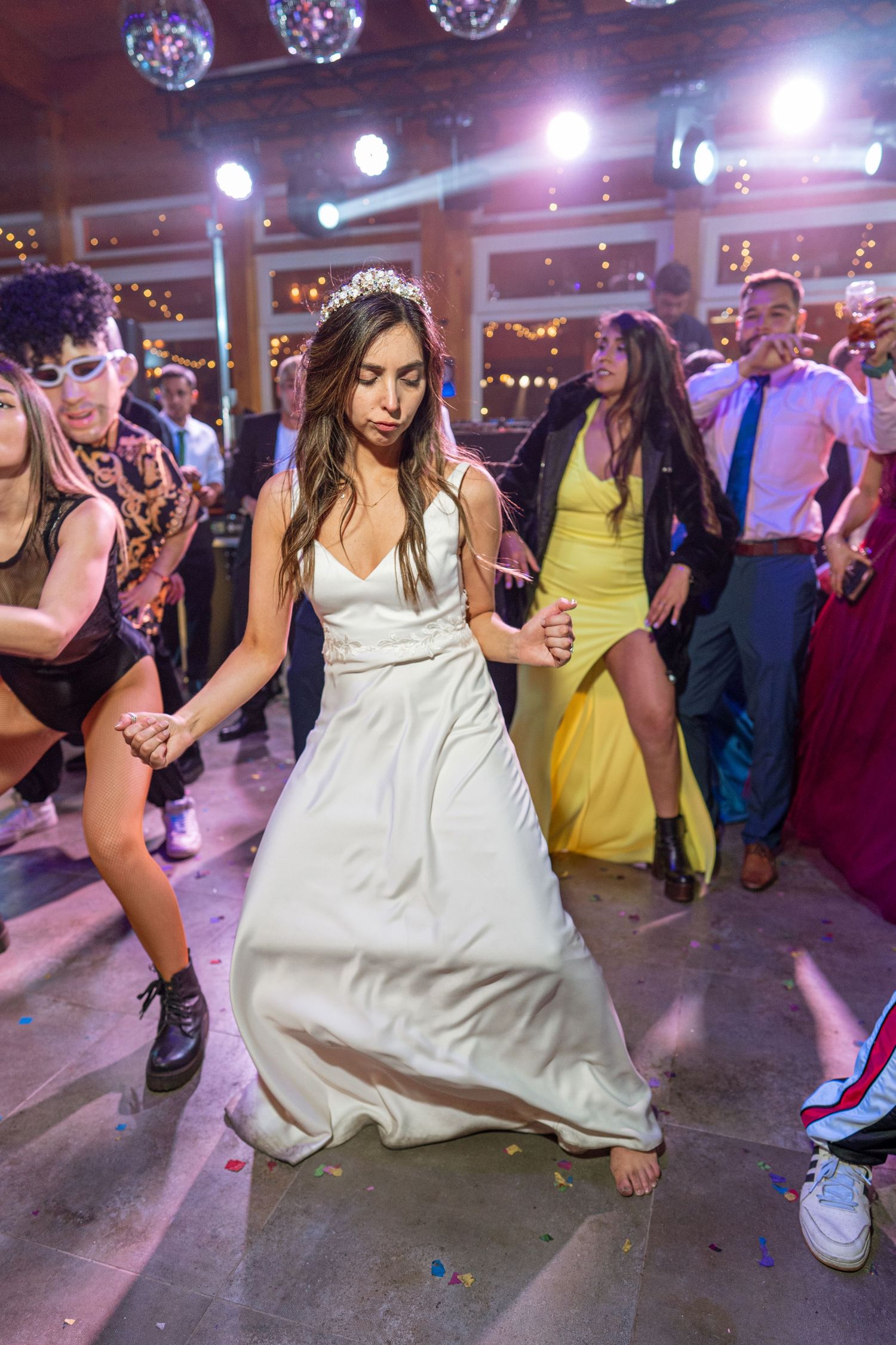 Dancers moving to music on a vibrant dance floor with disco lights overhead.