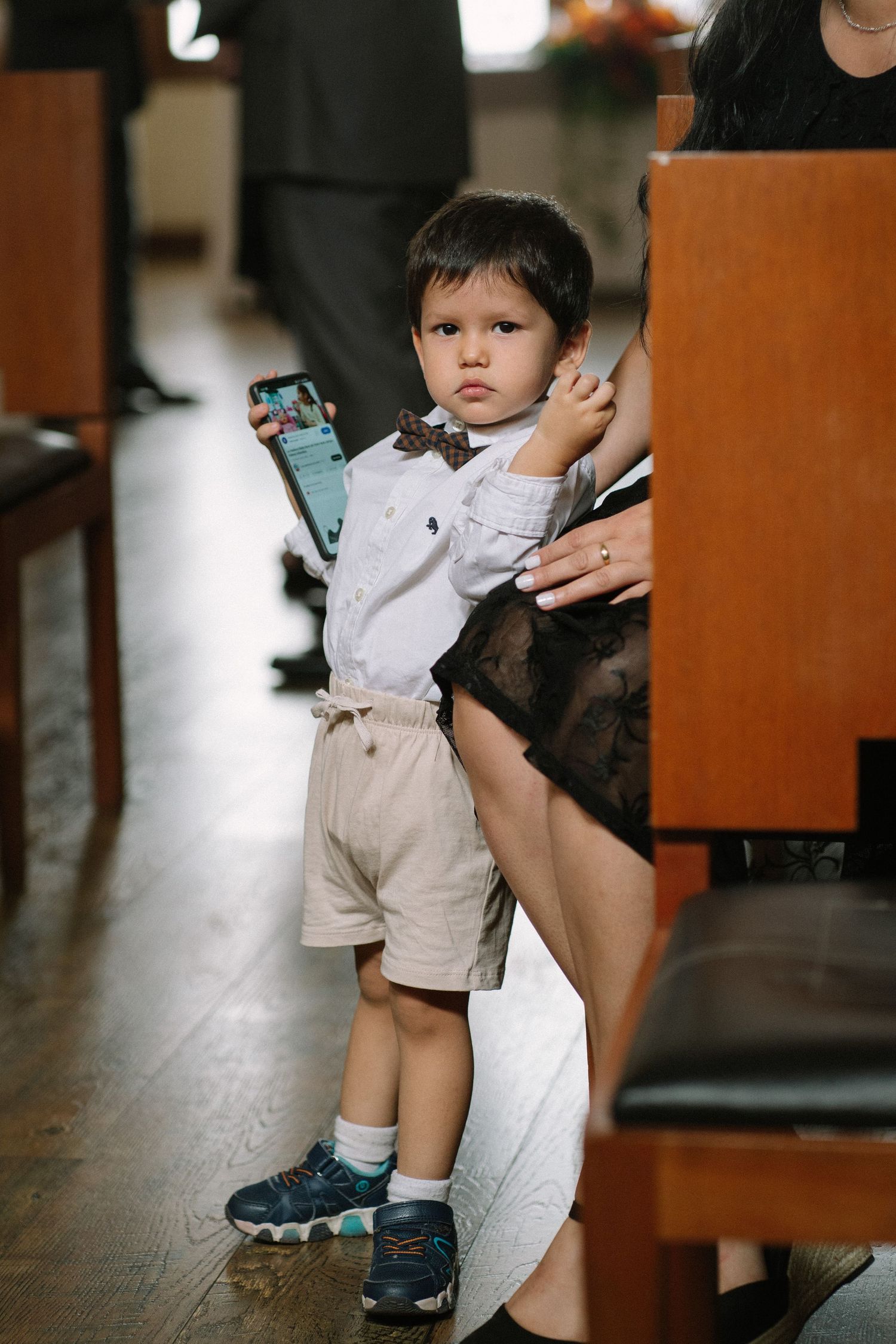A small child in formal attire standing in a restaurant or event space.