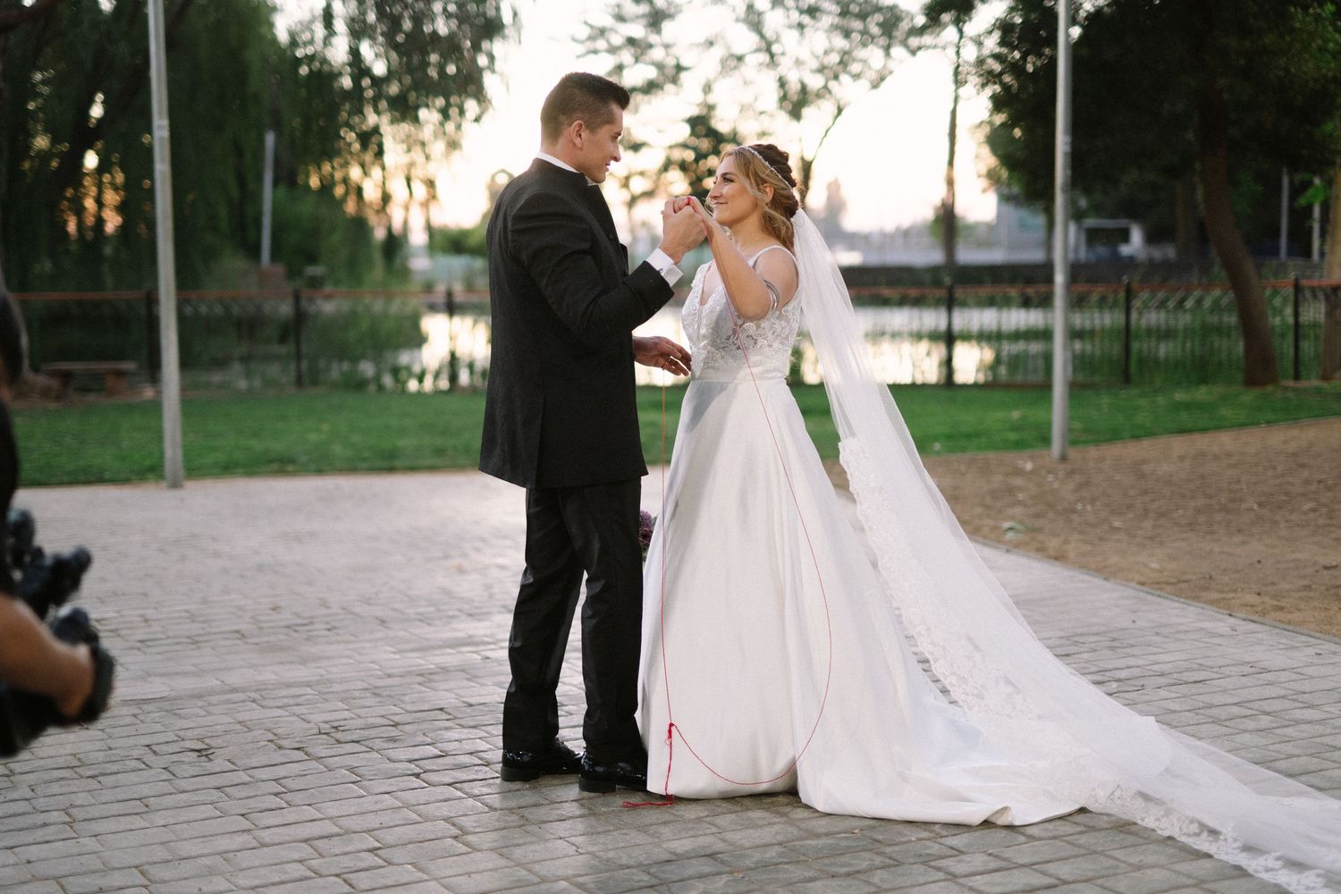 A bride and groom share a tender moment on their wedding day against a sunset backdrop.