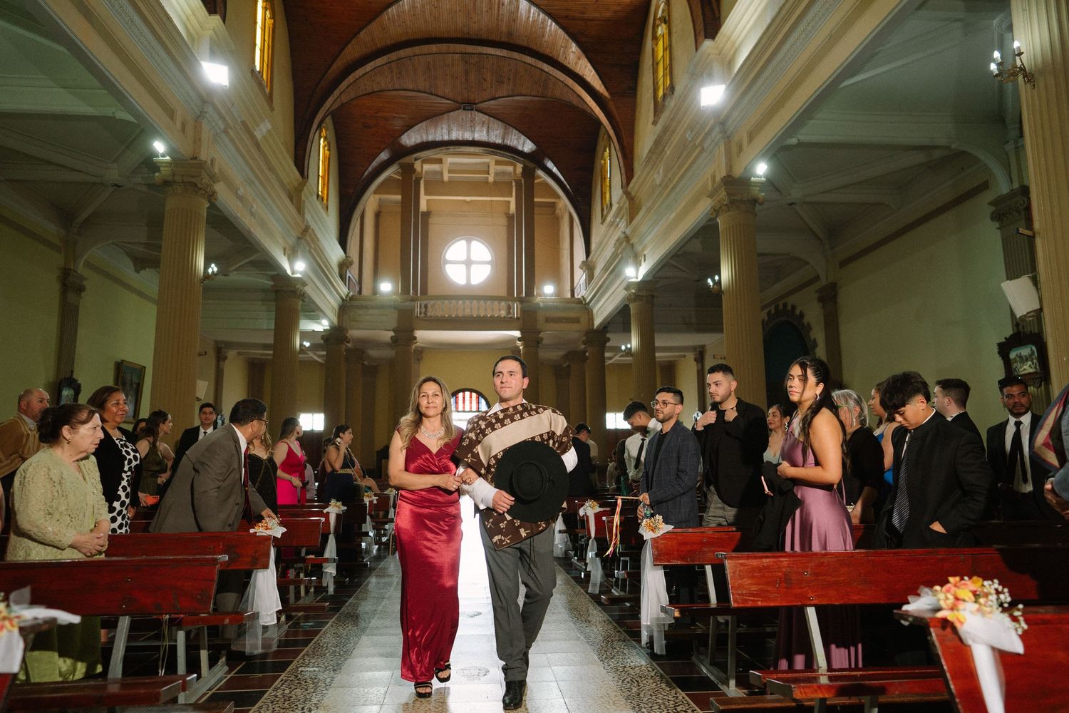 Wedding ceremony in a historic church with vaulted ceilings and wooden pews.