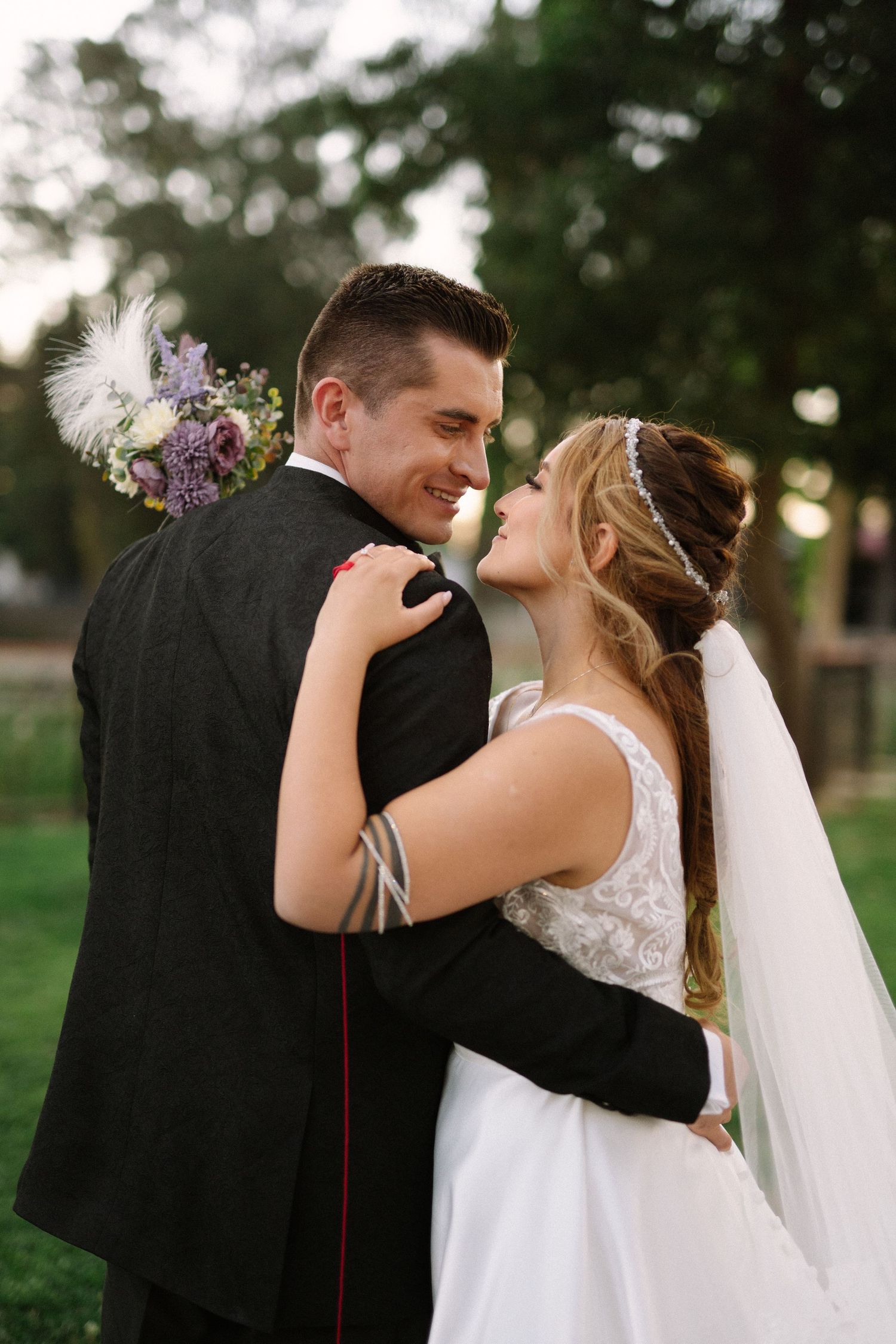 Romantic wedding couple embraces outdoors during their intimate photo session.