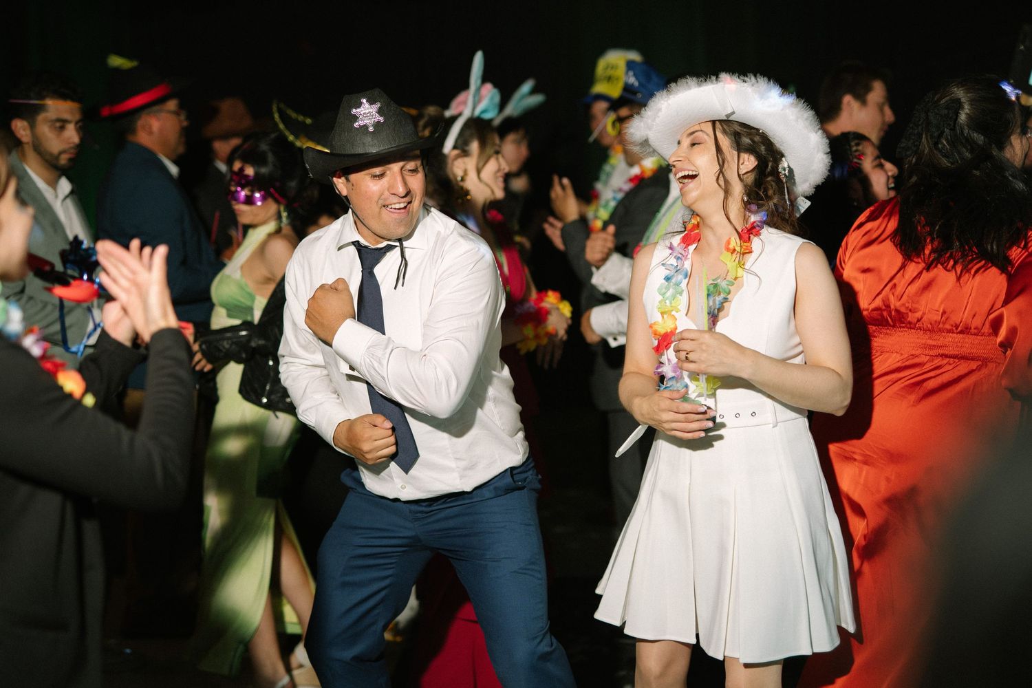 A lively dance scene with partygoers wearing cowboy hats and festive outfits.