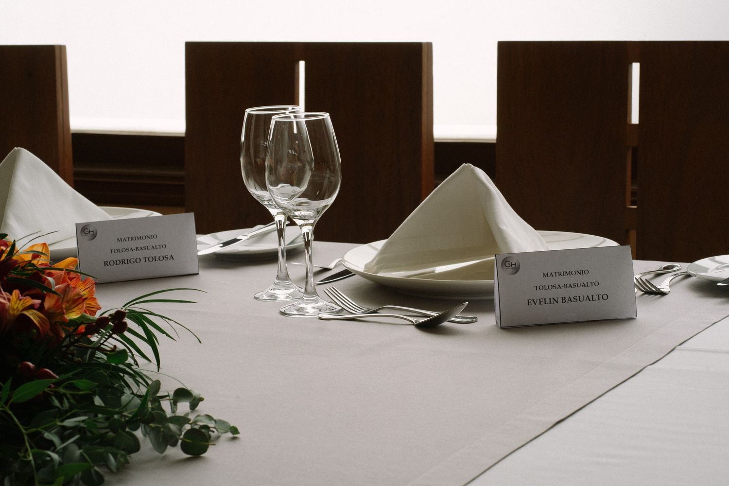 Elegant table setting with wine glasses, name cards, and folded napkins.