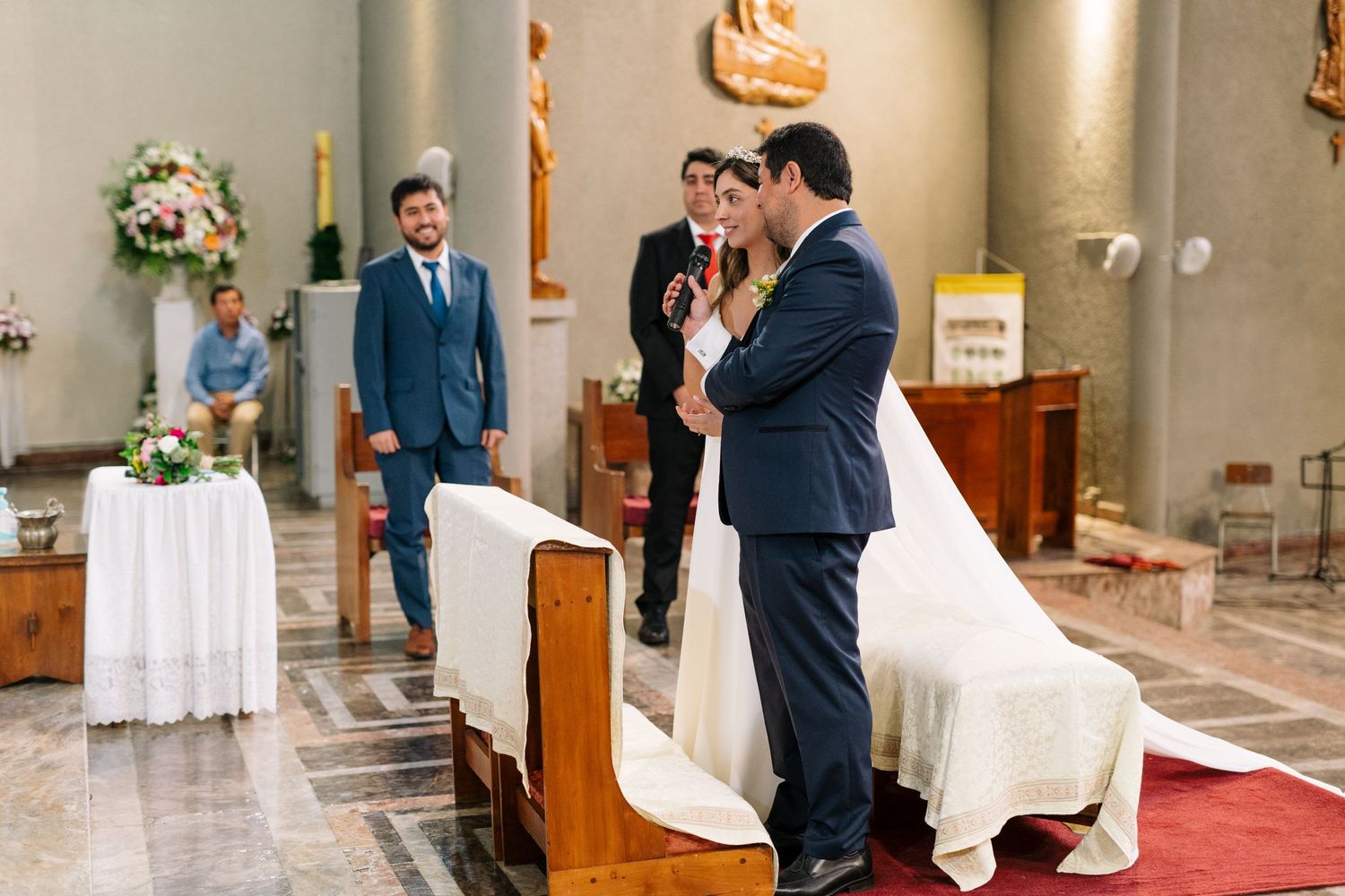 A couple shares their first kiss during a Catholic church wedding ceremony.