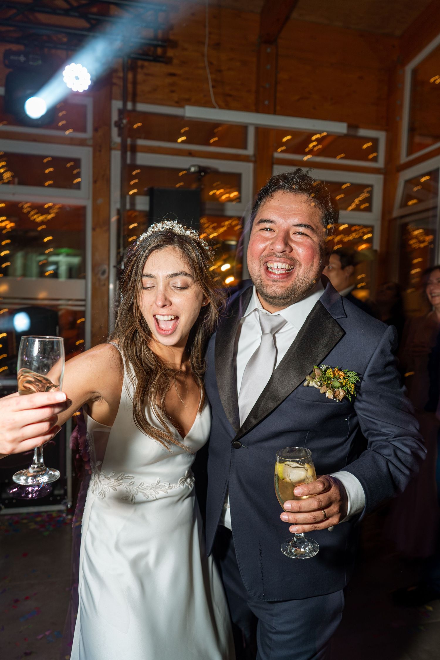 A celebratory moment at a wedding reception with drinks and laughter.
